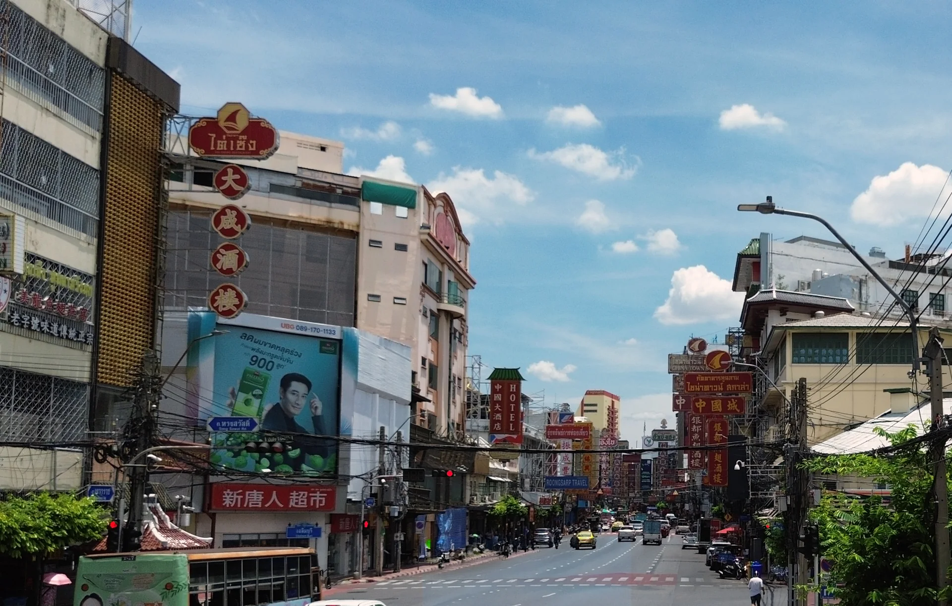 Rua Yaowarat em Bangkok durante o dia, com fachadas, letreiros em tailandês e chinês e trânsito urbano.