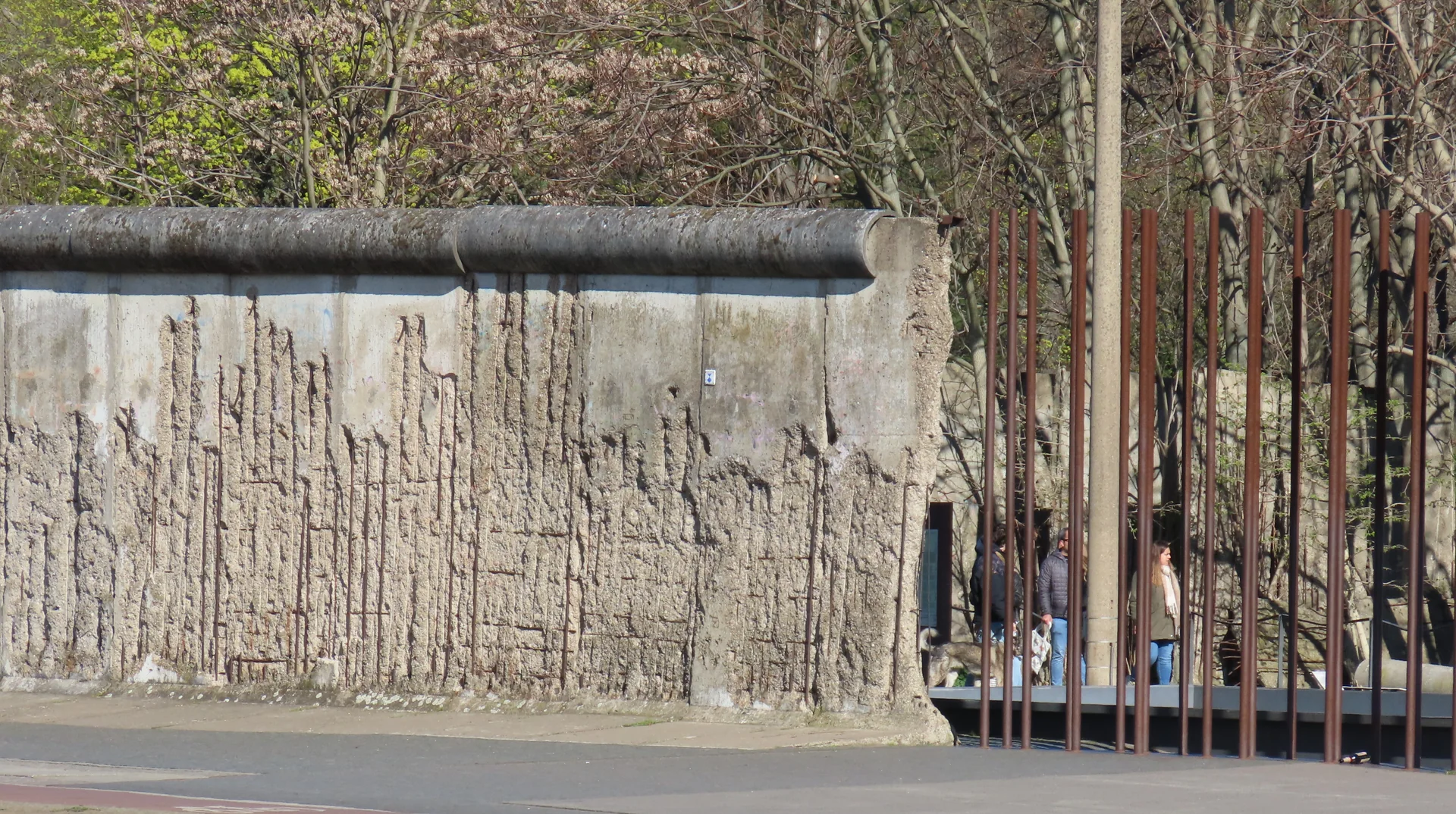 Trecho preservado do Muro de Berlim no Memorial da Bernauer Straße, com estrutura de barras de aço ao lado.