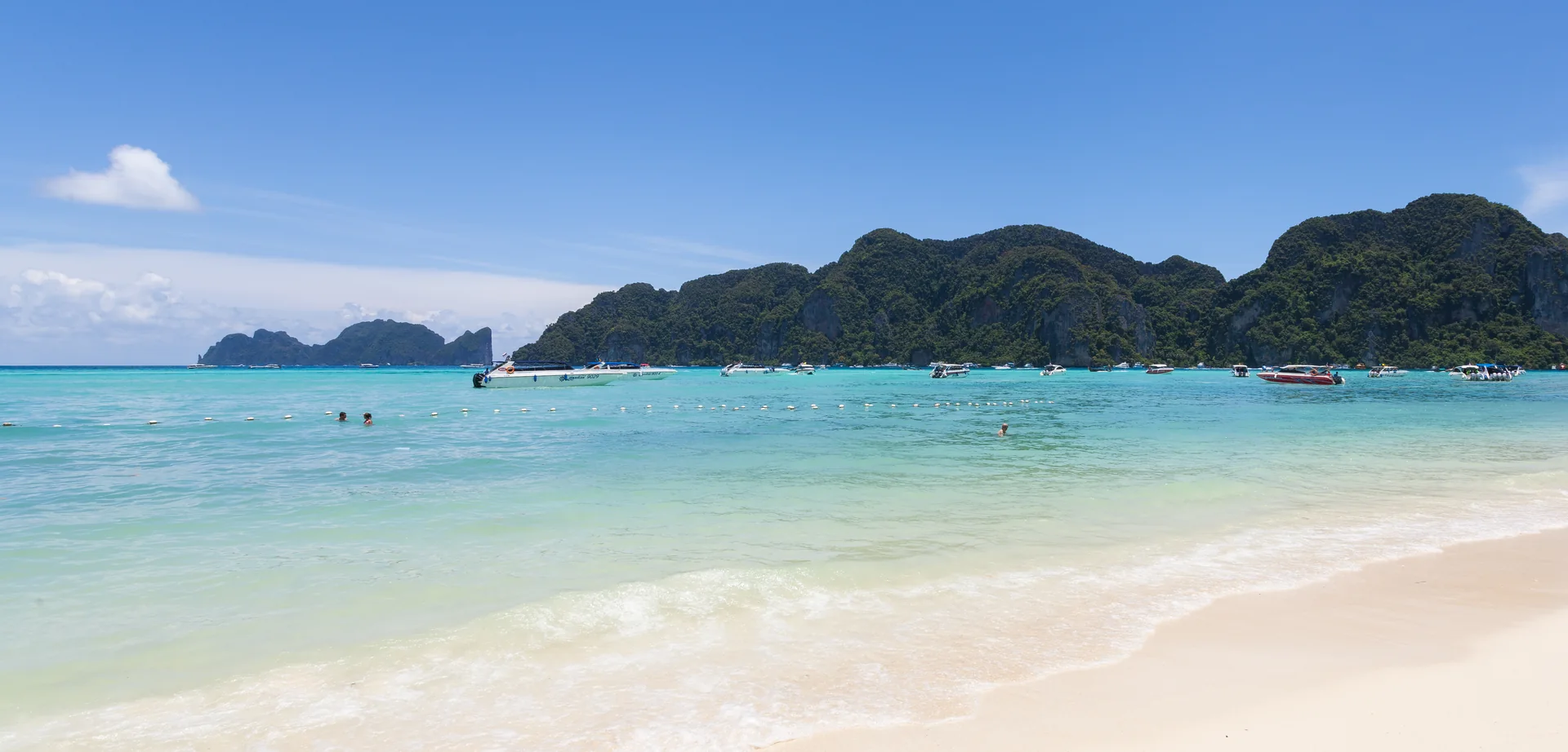 Vista costeira de Ko Phi Phi Don, com mar, praia e relevo calcário.