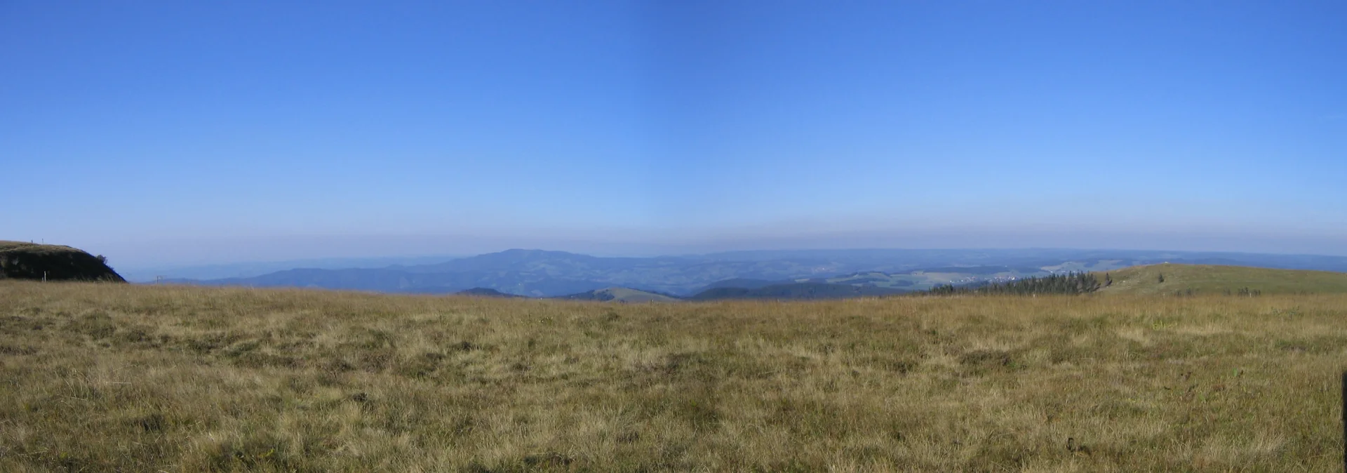 Panorama visto do cume do Feldberg, com campos de altitude e montanhas da Floresta Negra.