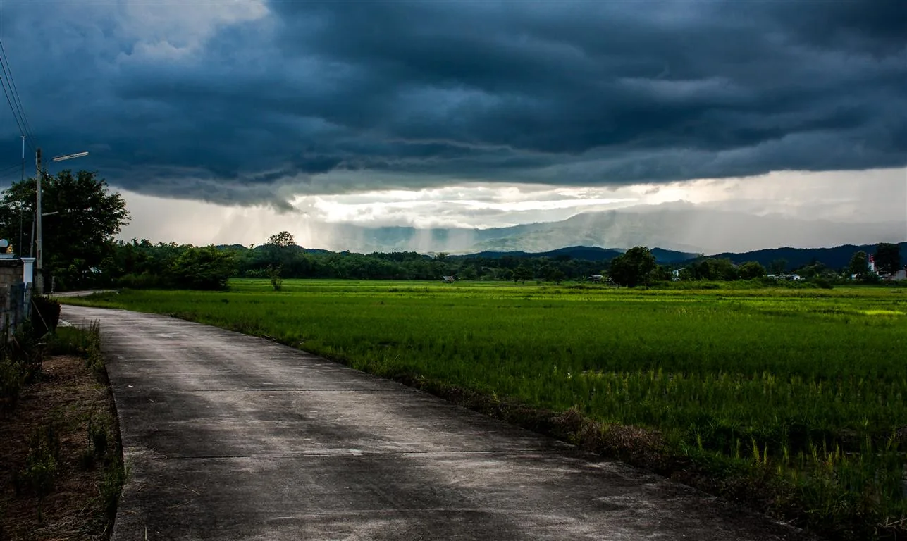 Cortina de chuva de verão atravessando vales montanhosos ao sul de Chiang Rai.