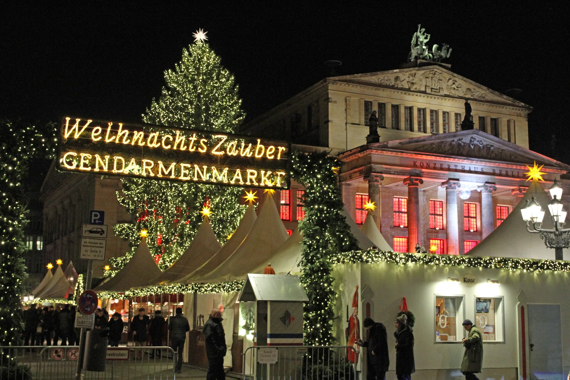 Mercado de Natal iluminado no Gendarmenmarkt, em Berlim, com o Konzerthaus ao fundo.