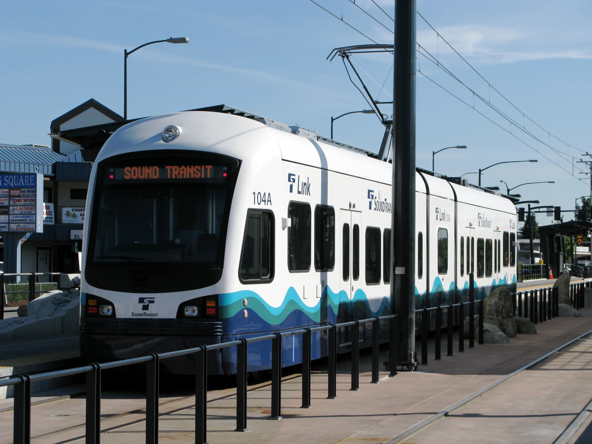 Trem branco e azul do Link light rail da Sound Transit em uma estação de Seattle.