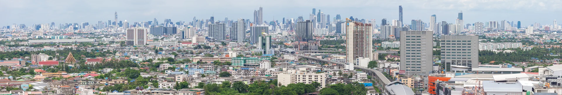 Panorama de Bangkok visto de um edifício alto, com bairros e torres no horizonte.