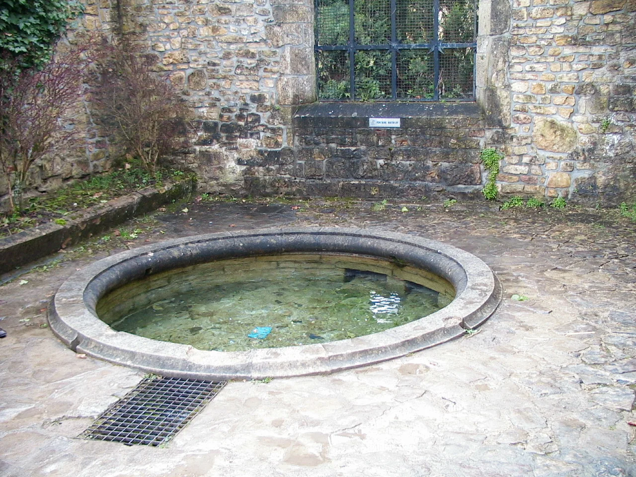 Fonte Mathilde, de pedra, em meio ao sítio histórico da Abadia de Orval.