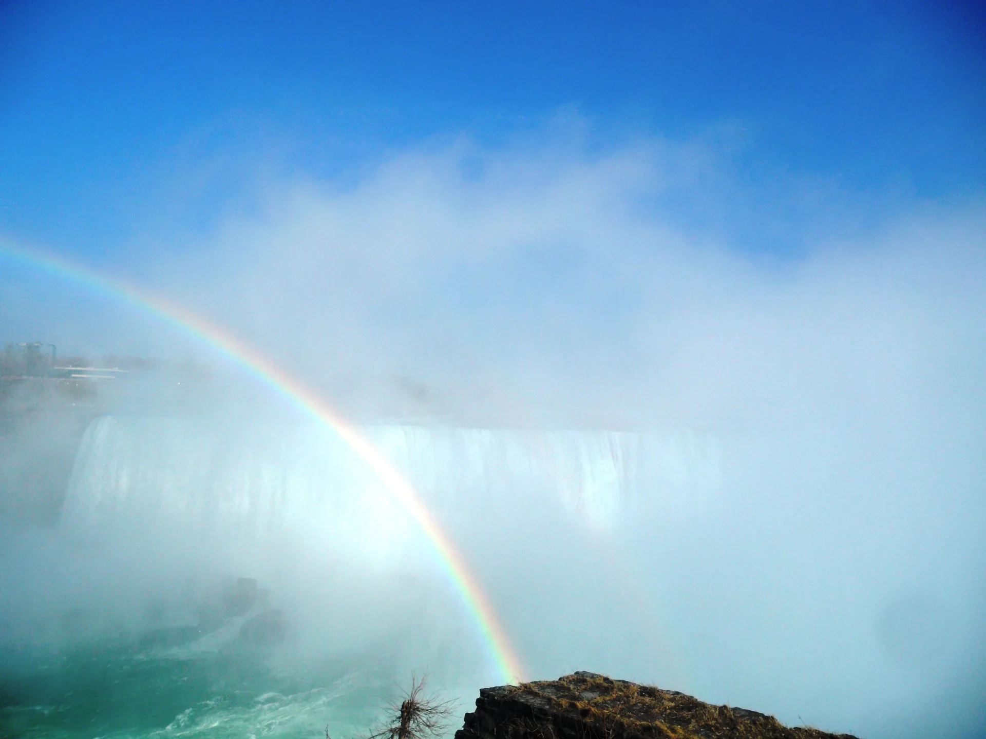 Arco-íris sobre a névoa das Horseshoe Falls visto da Niagara River Parkway