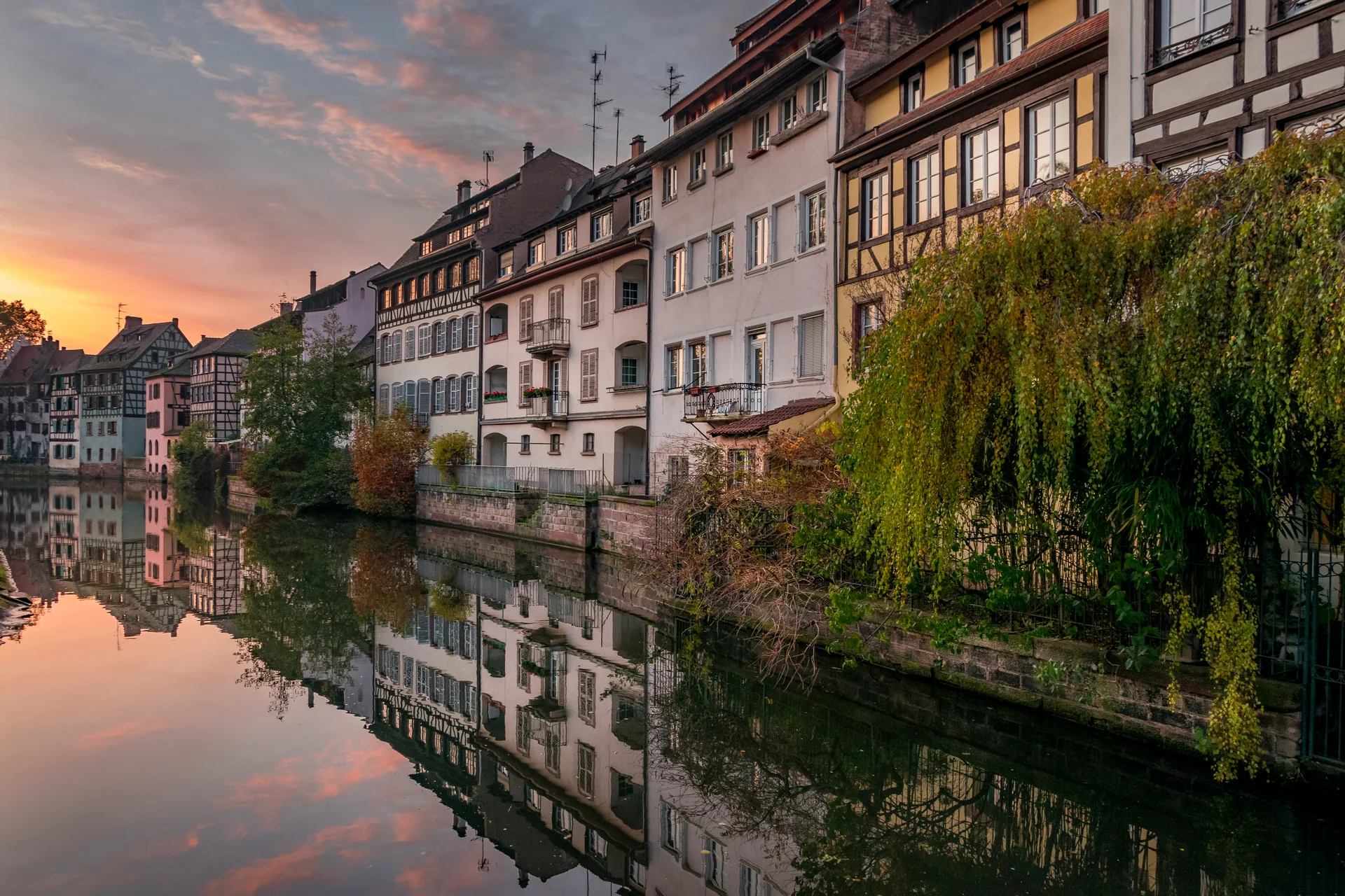 Casas históricas à margem de um canal em Petite France, Estrasburgo, ao entardecer