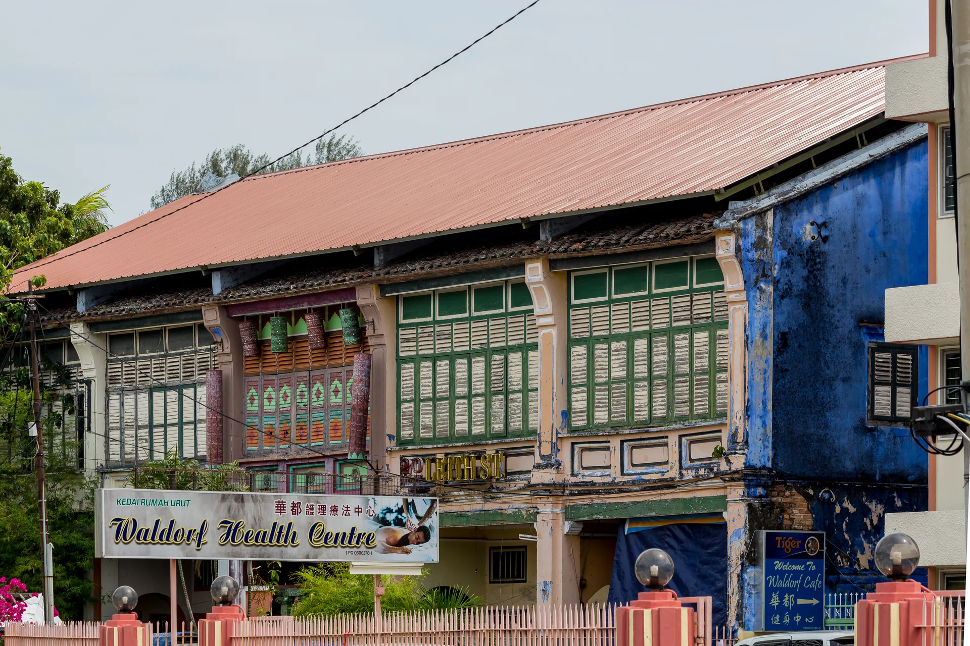 Fachada colorida de uma casa histórica em Leith Street, George Town, com venezianas e elementos decorativos.