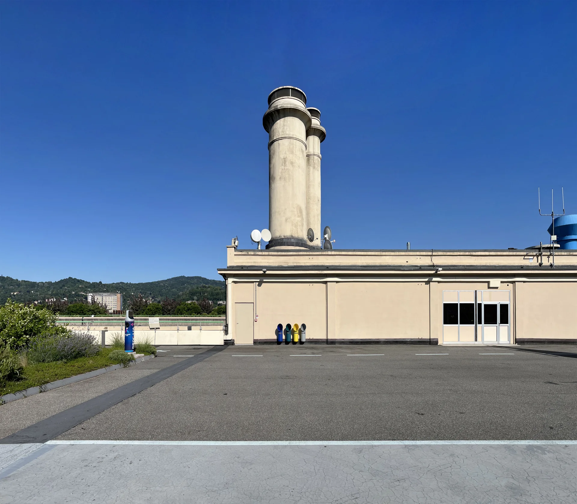 Chaminés e estrutura da antiga fábrica FIAT na cobertura do Lingotto sob céu azul