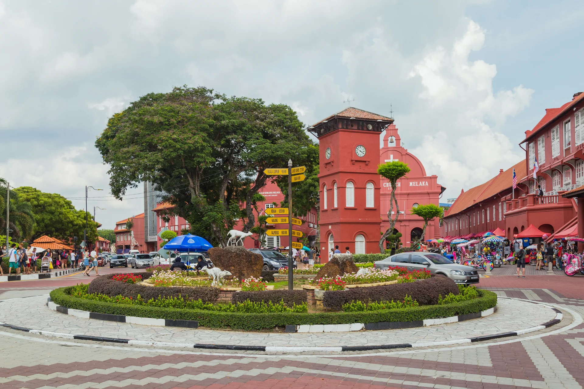 Dutch Square em Melaka sob luz natural, com a torre do relógio, Christ Church e edifícios históricos vermelhos.