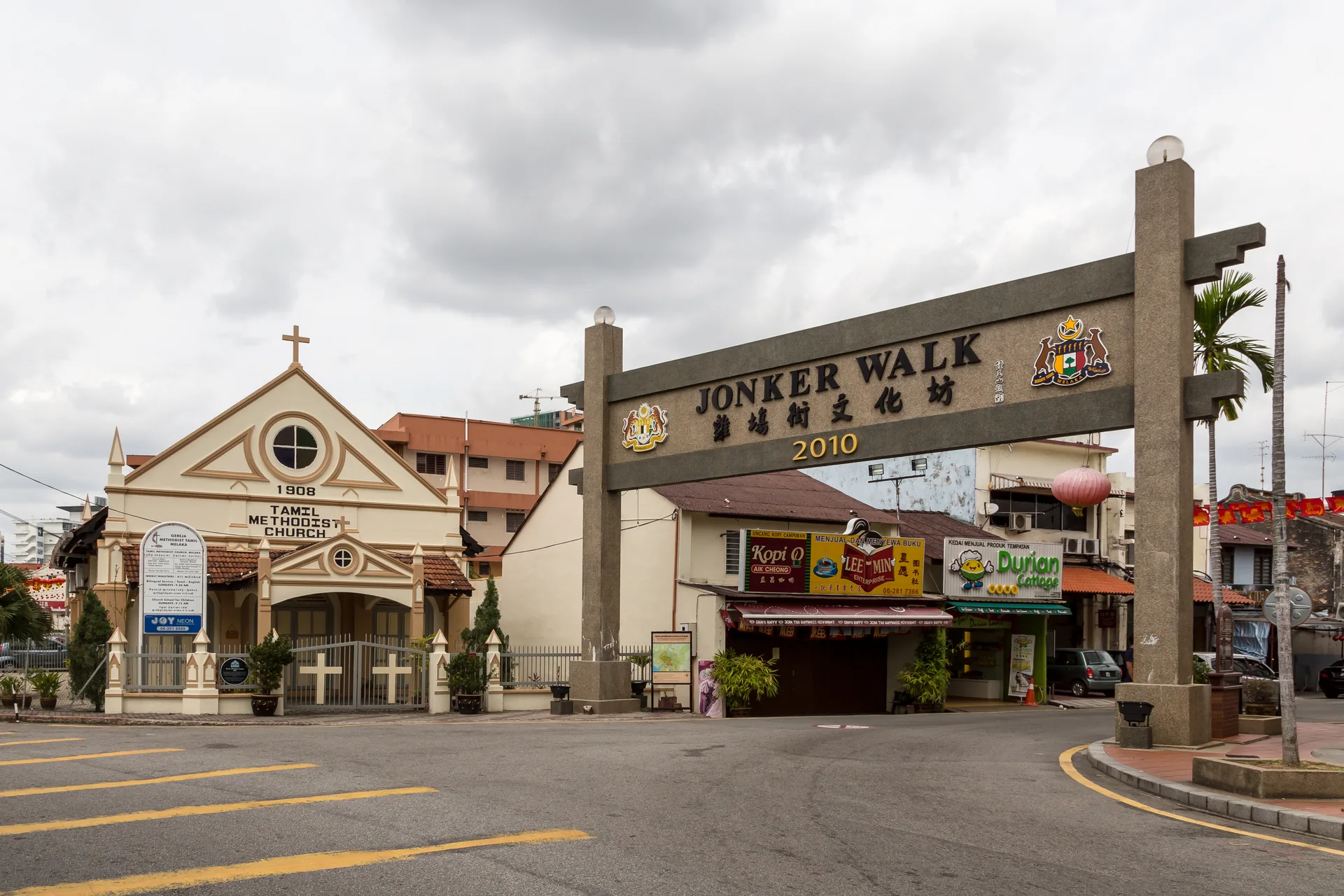 Portal de Jonker Walk e fachada da igreja metodista tâmil em Melaka sob luz diurna.