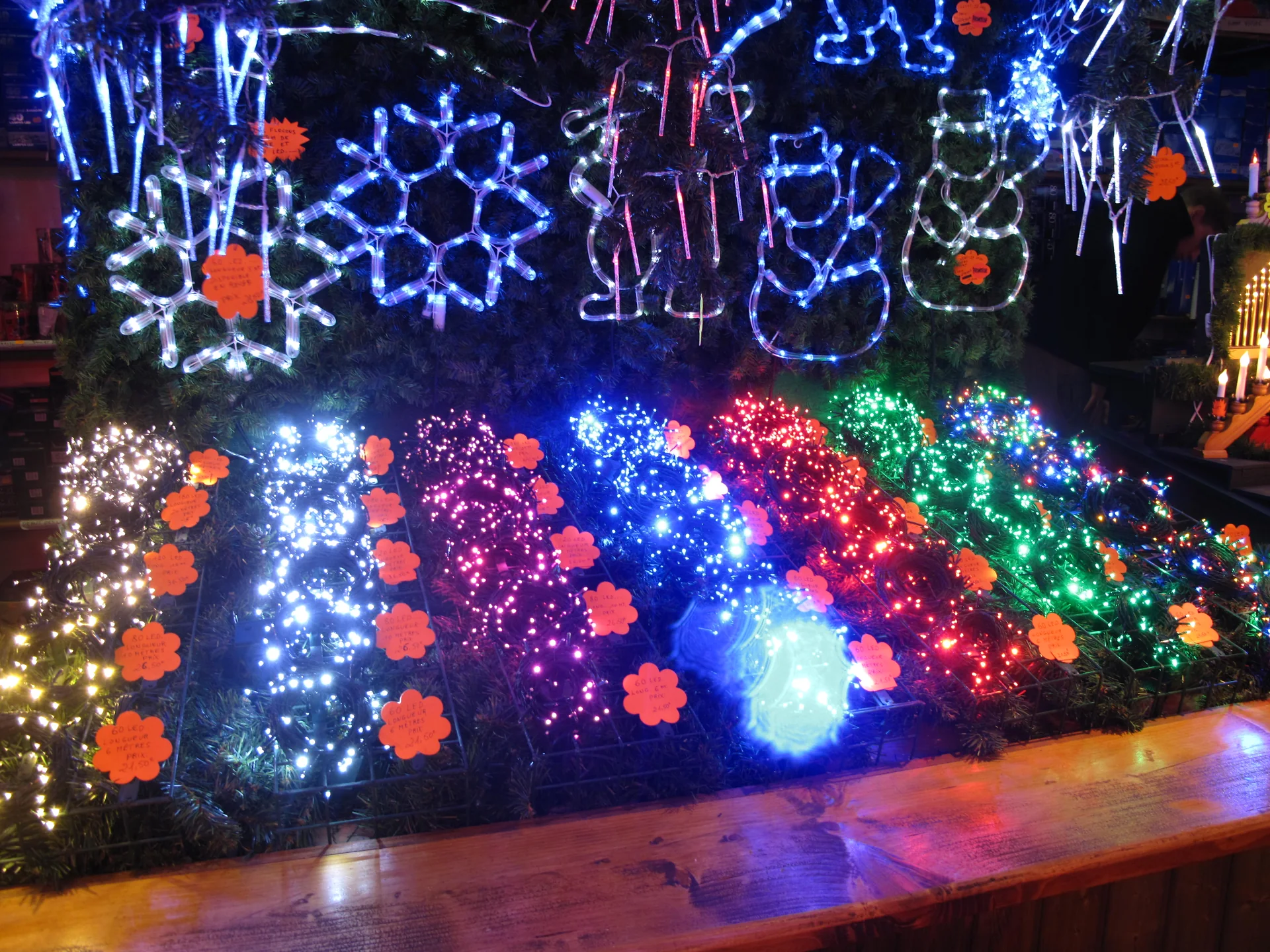 Luzes e enfeites coloridos expostos em um chalé do mercado de Natal de Estrasburgo.