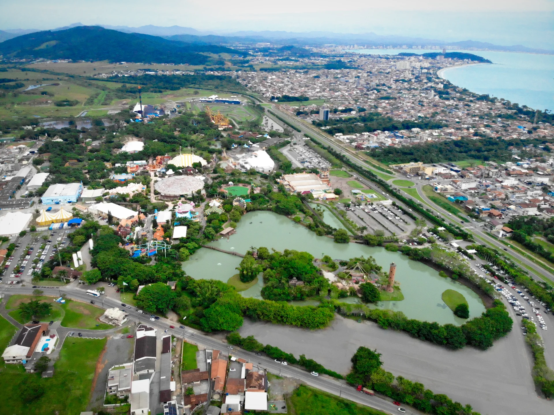 Vista aérea do Beto Carrero World em Penha, com áreas temáticas, vegetação e entorno urbano