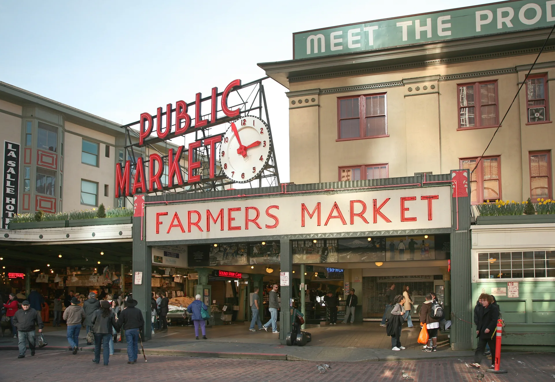 Entrada do Pike Place Market com o letreiro Public Market Center e visitantes durante o dia.