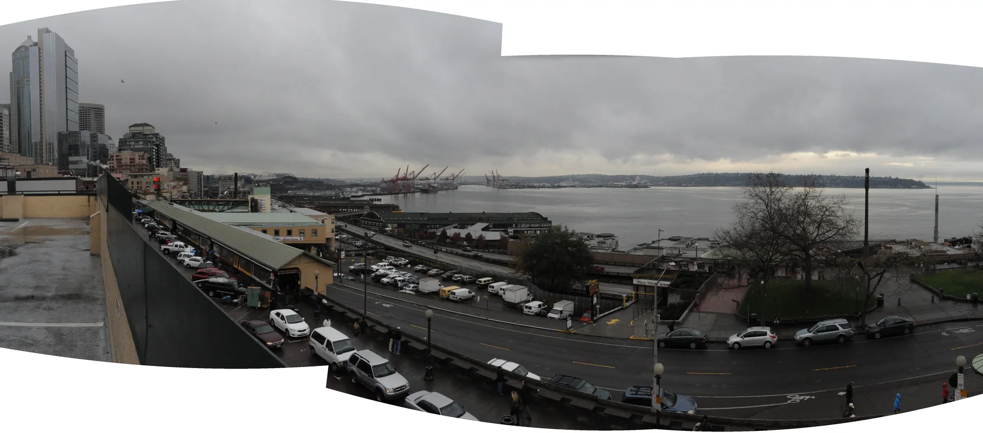 Vista panorâmica do Pike Place Market e de Elliott Bay durante o dia, a partir do entorno de Downtown Seattle.