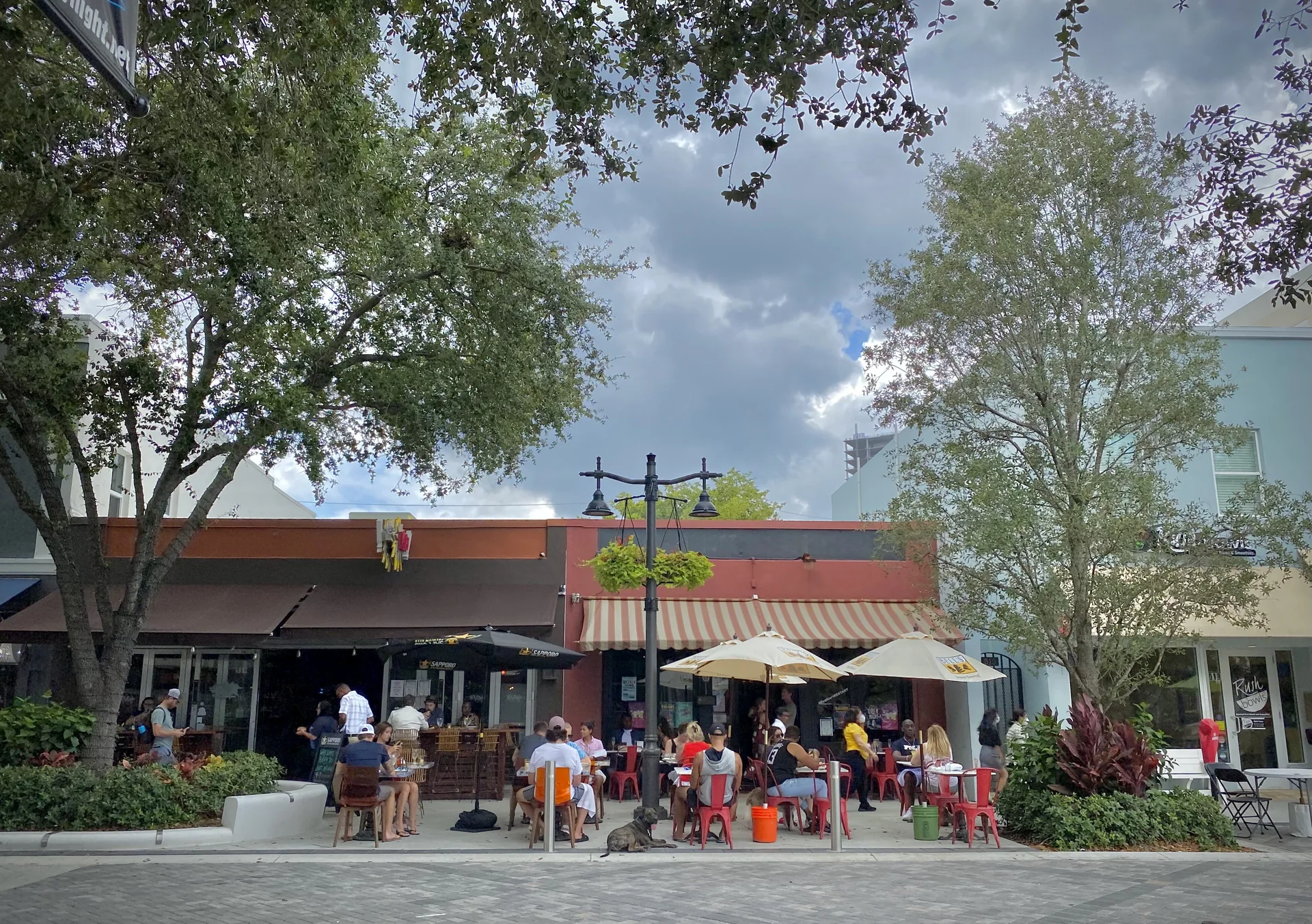 Mesas de restaurantes em calçada de Clematis Street, no centro de West Palm Beach, em dia claro.
