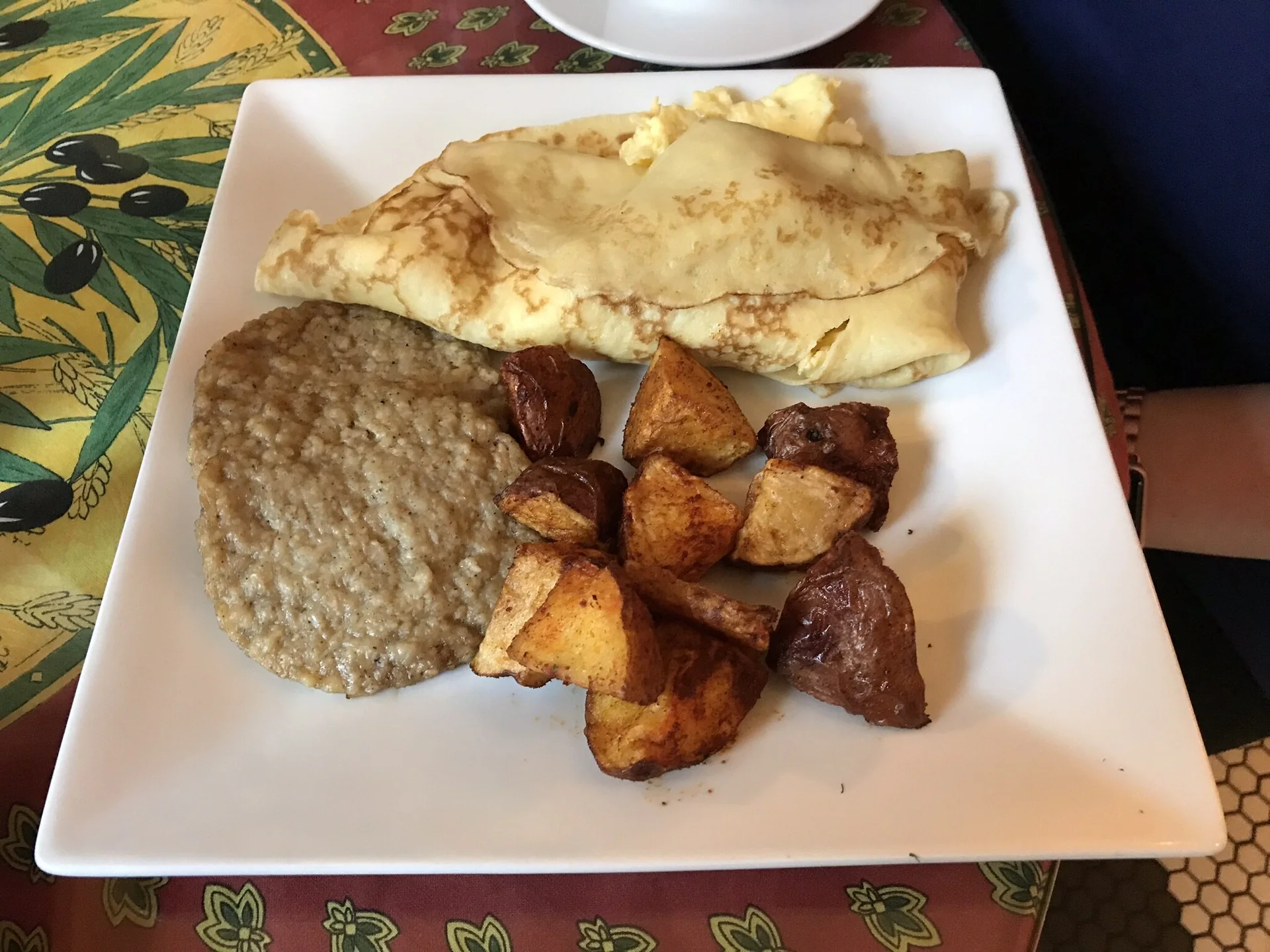 Pratos de café da manhã, incluindo crepe, grits e hash, servidos sobre mesa em West Palm Beach.