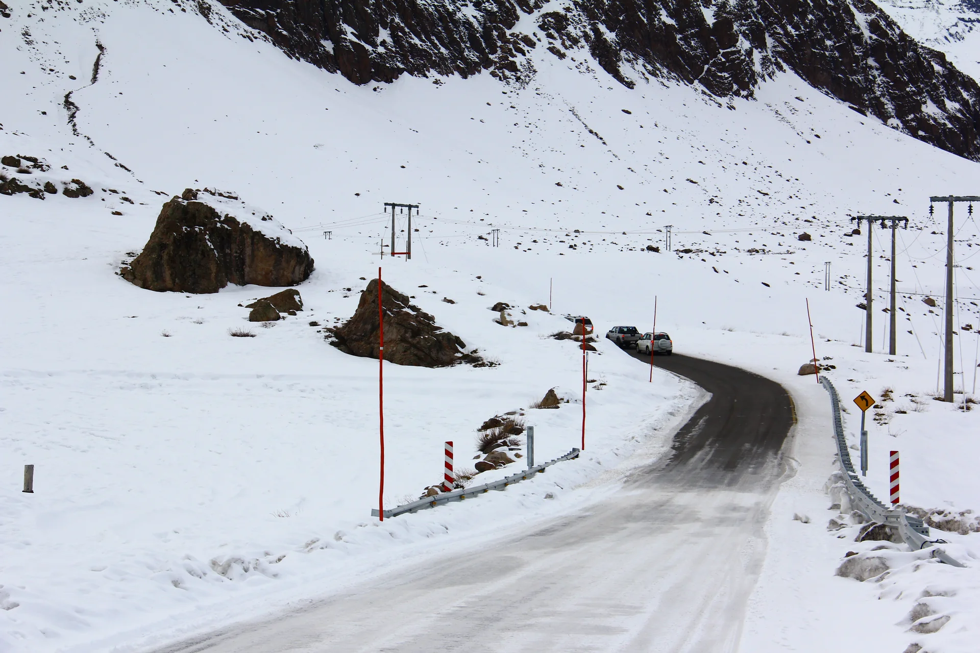 Estrada sinuosa coberta de neve a caminho de Valle Nevado, em cenário montanhoso de inverno.