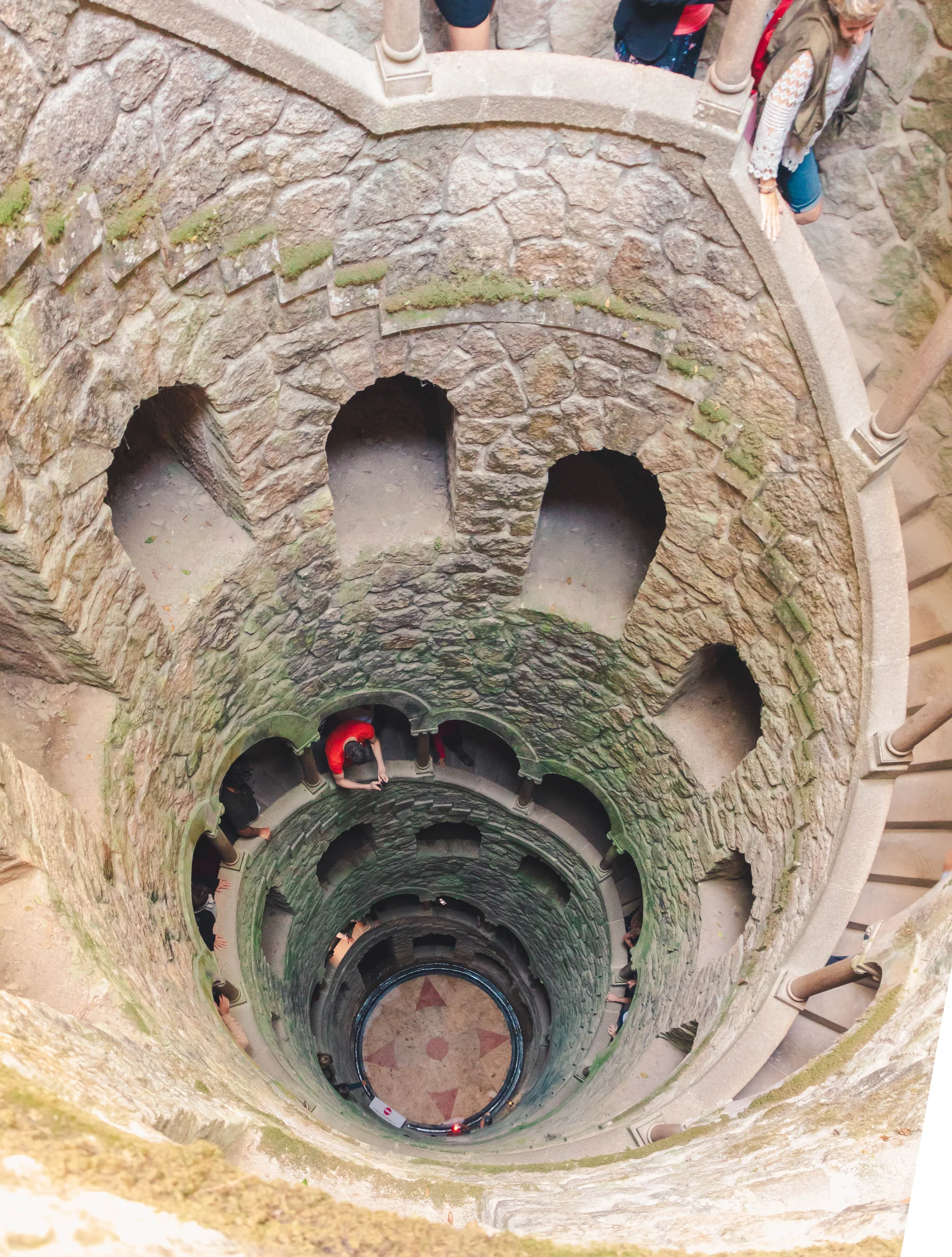 Vista vertical do Poço Iniciático da Quinta da Regaleira, com escadaria helicoidal e fundo do poço.