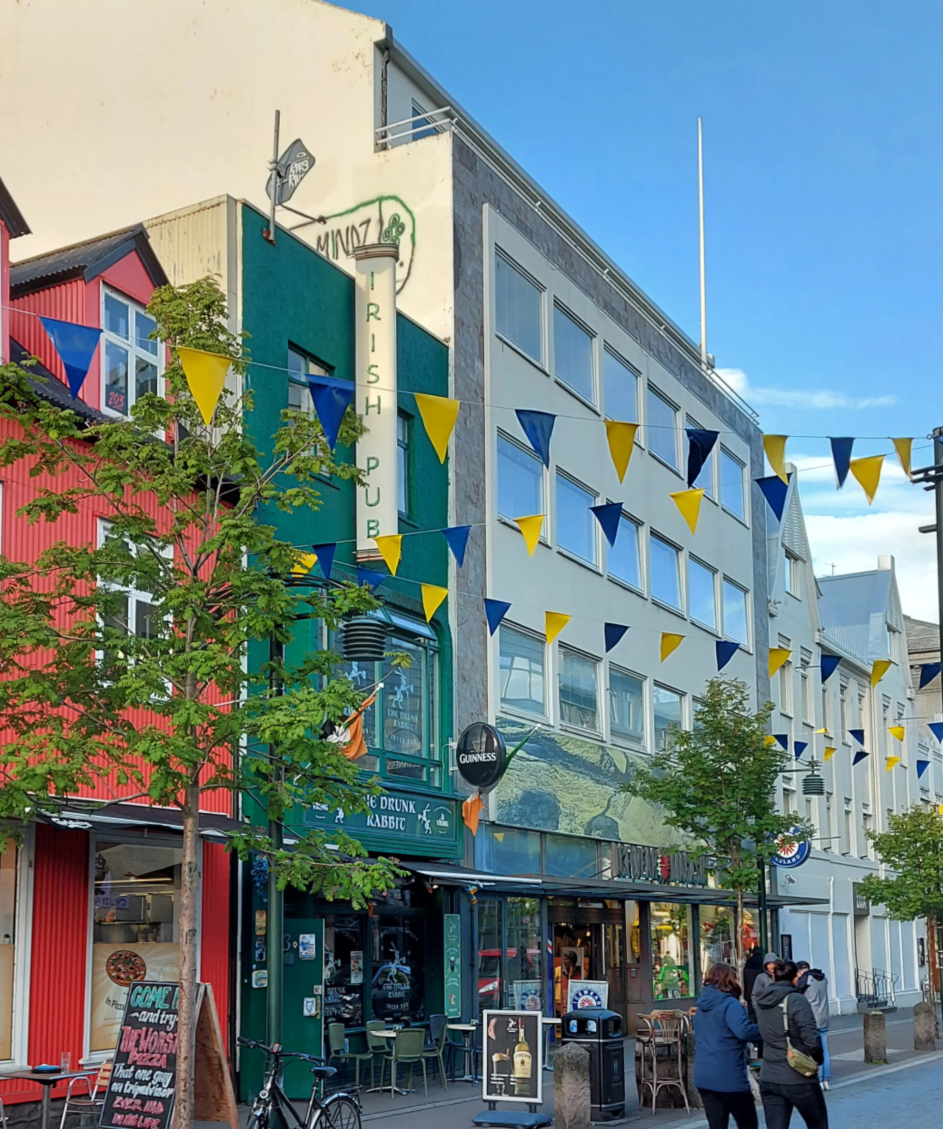 Fachadas coloridas, cafés e pedestres na rua Austurstræti, no centro de Reykjavík.