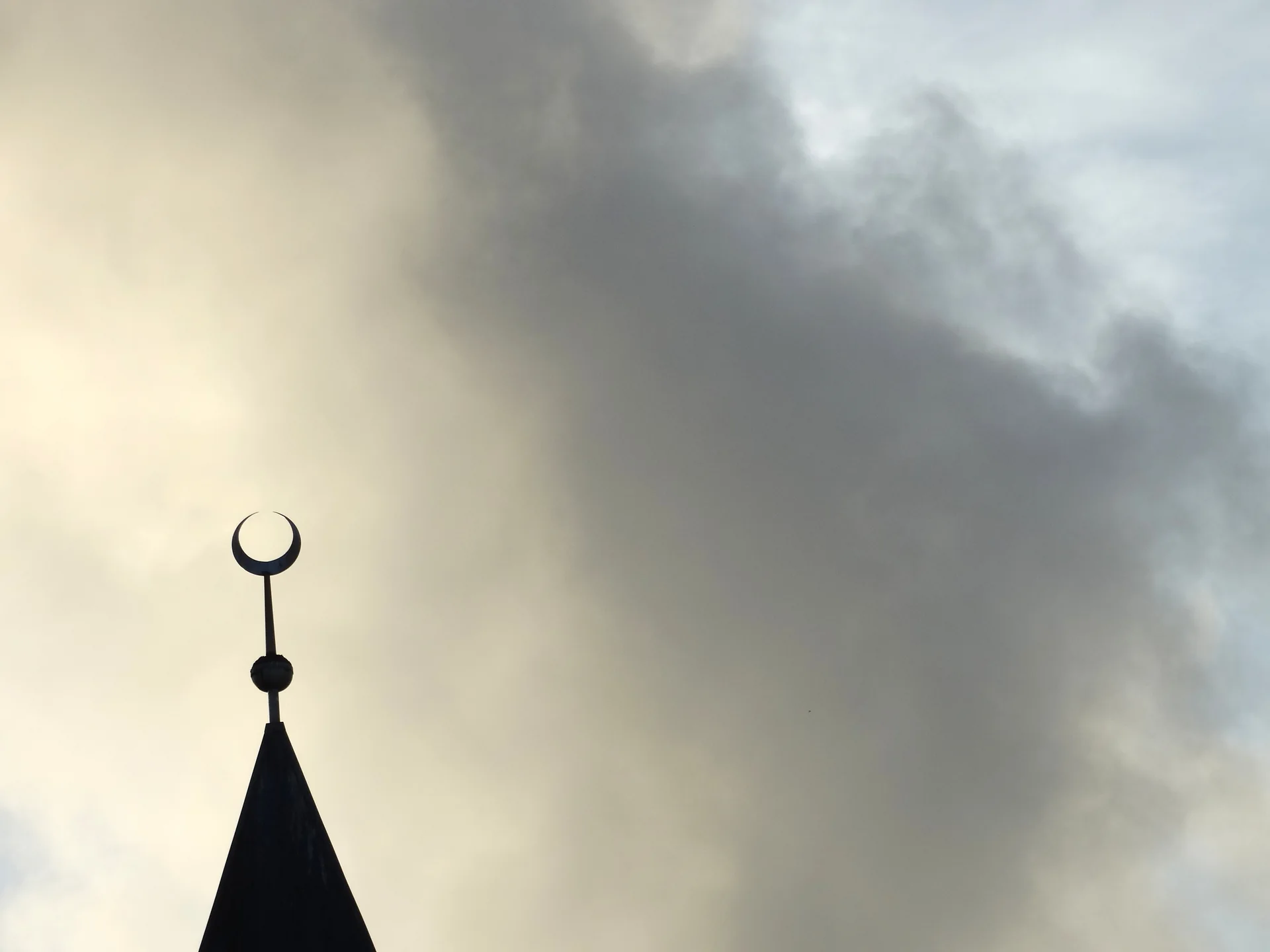 Minarete de mesquita em Maafushi visto externamente ao entardecer, sem pessoas identificáveis nem ritual em curso.