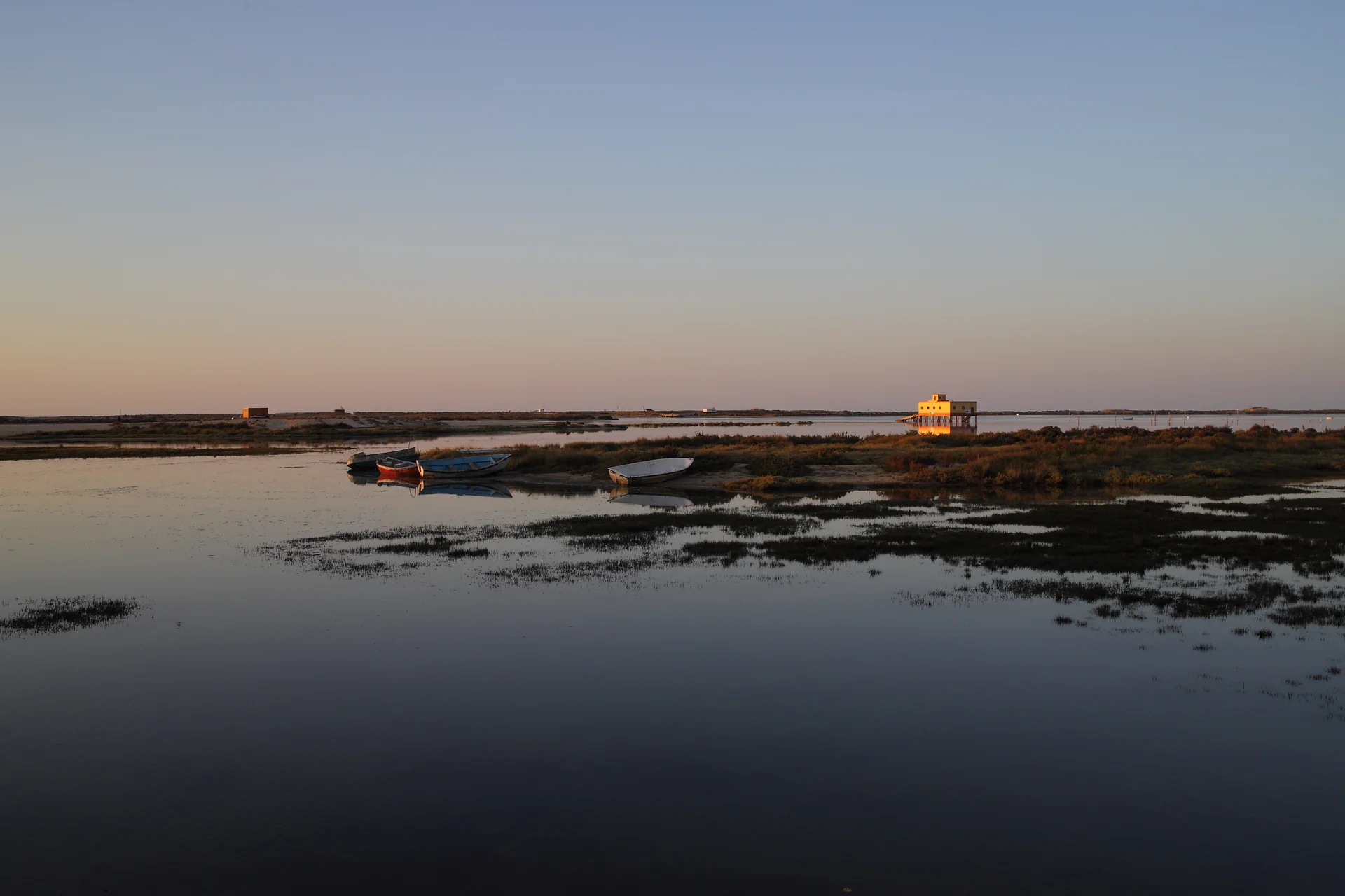 Vista matinal da frente lagunar de Fuzeta, no leste do Algarve, com água e tecido urbano ao fundo.