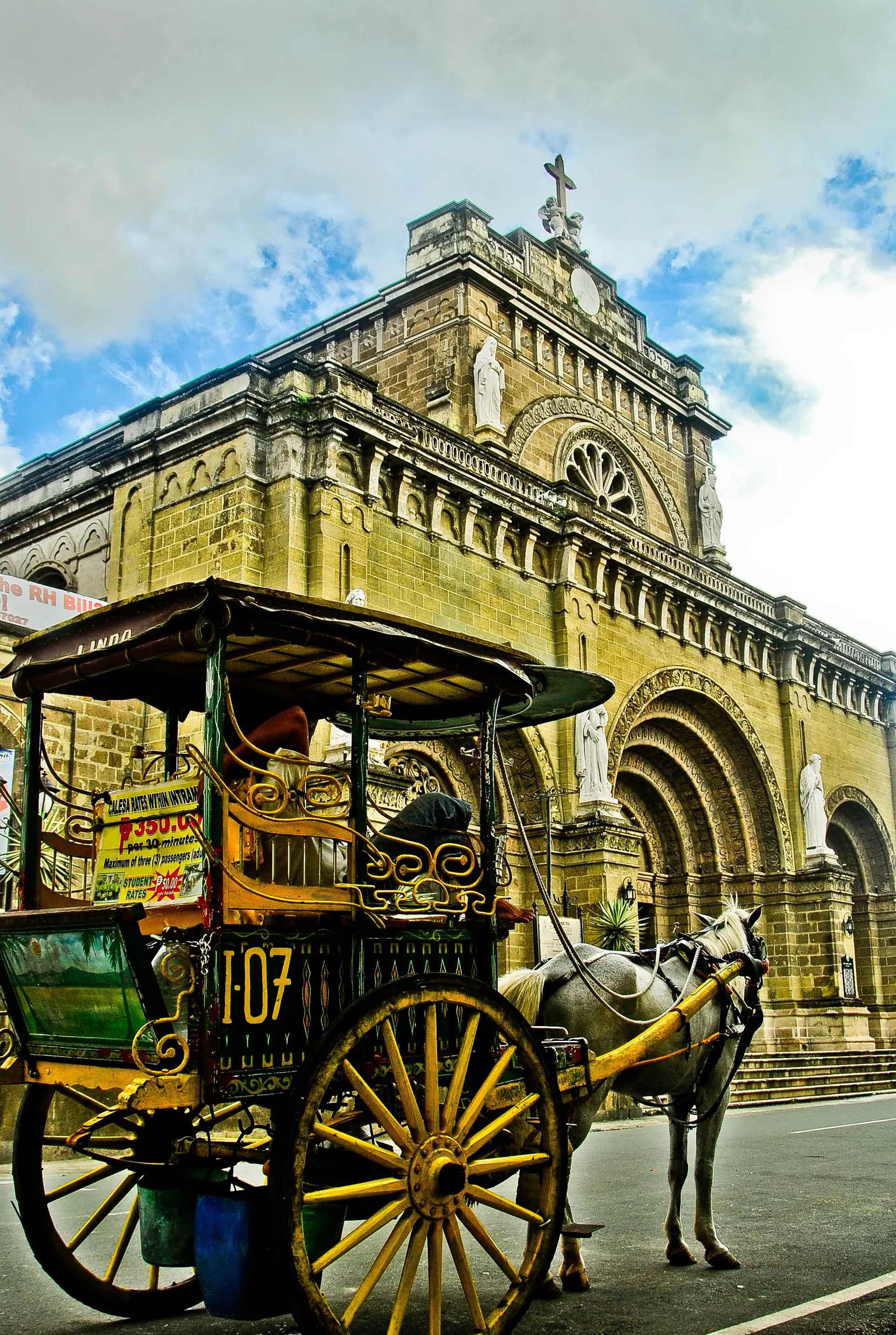 Catedral de Manila e uma calesa em rua de Intramuros, sob luz solar, em fotografia de 2012.