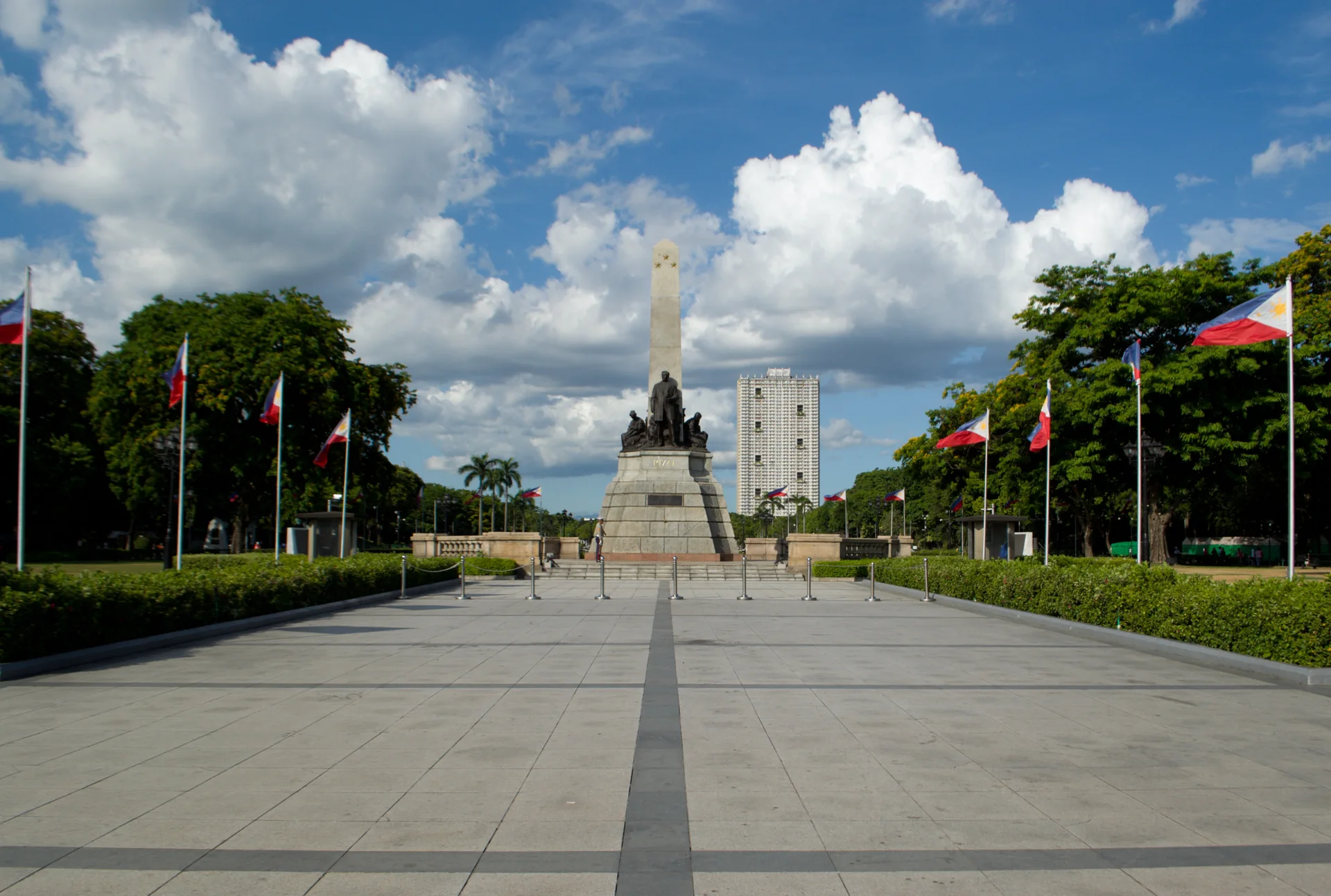 Monumento a José Rizal no Rizal Park, em Manila, sob luz solar, em fotografia de 2024.