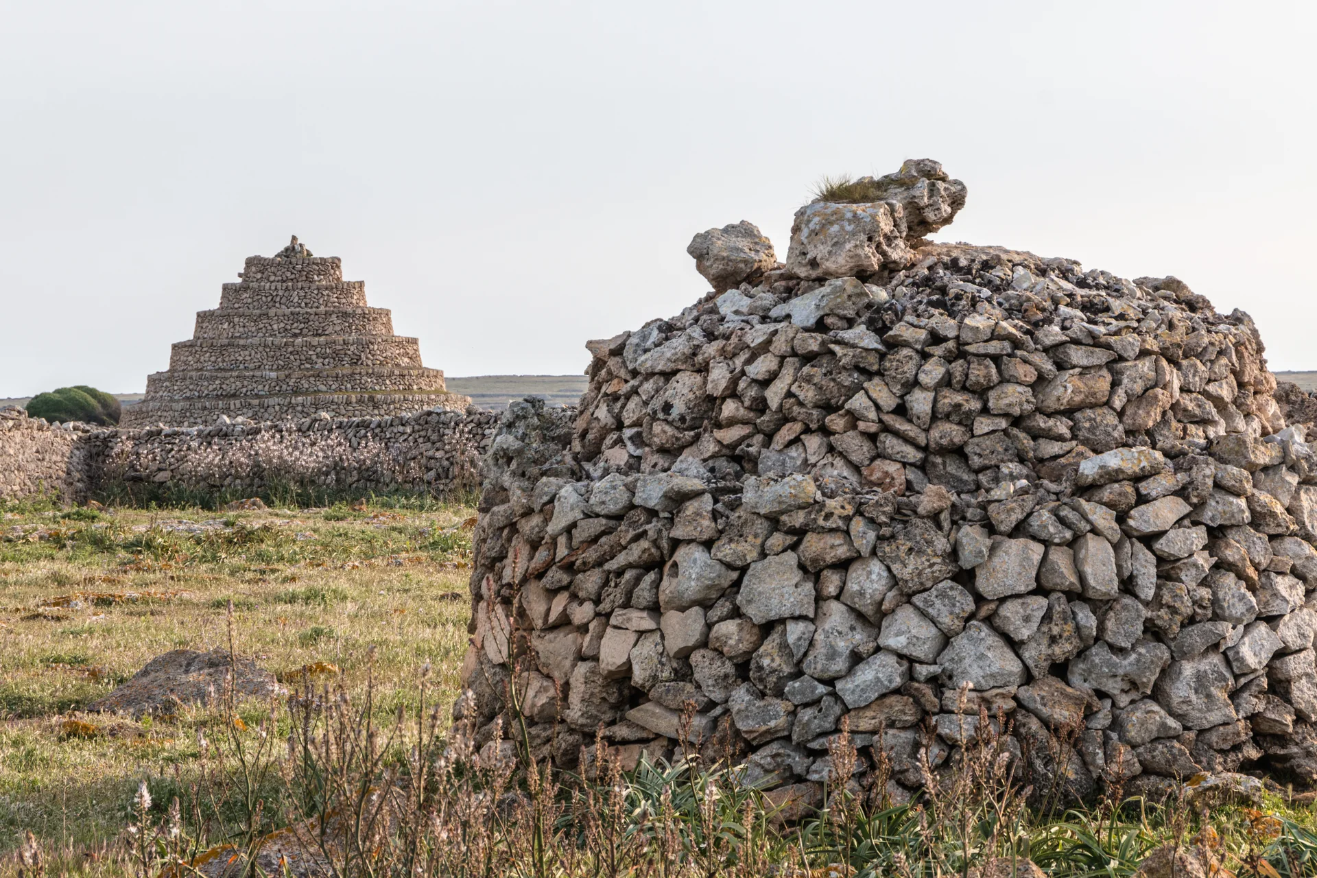 Abrigos de gado e muros de pedra seca em campo aberto perto de Punta Nati, no oeste de Menorca.