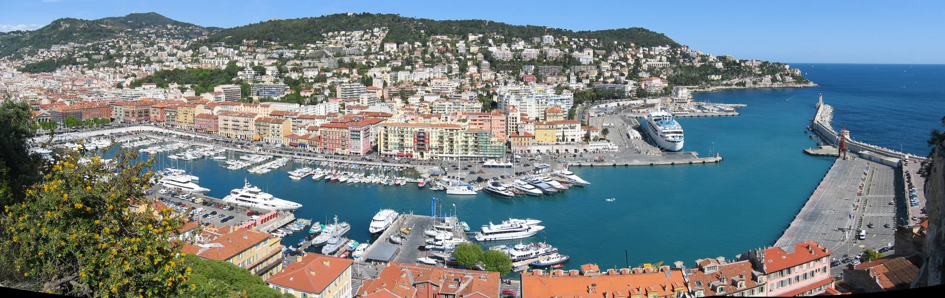 Panorama do Porto Lympia em Nice, com a bacia portuária, edifícios da cidade, quebra-mar e Mont Boron.