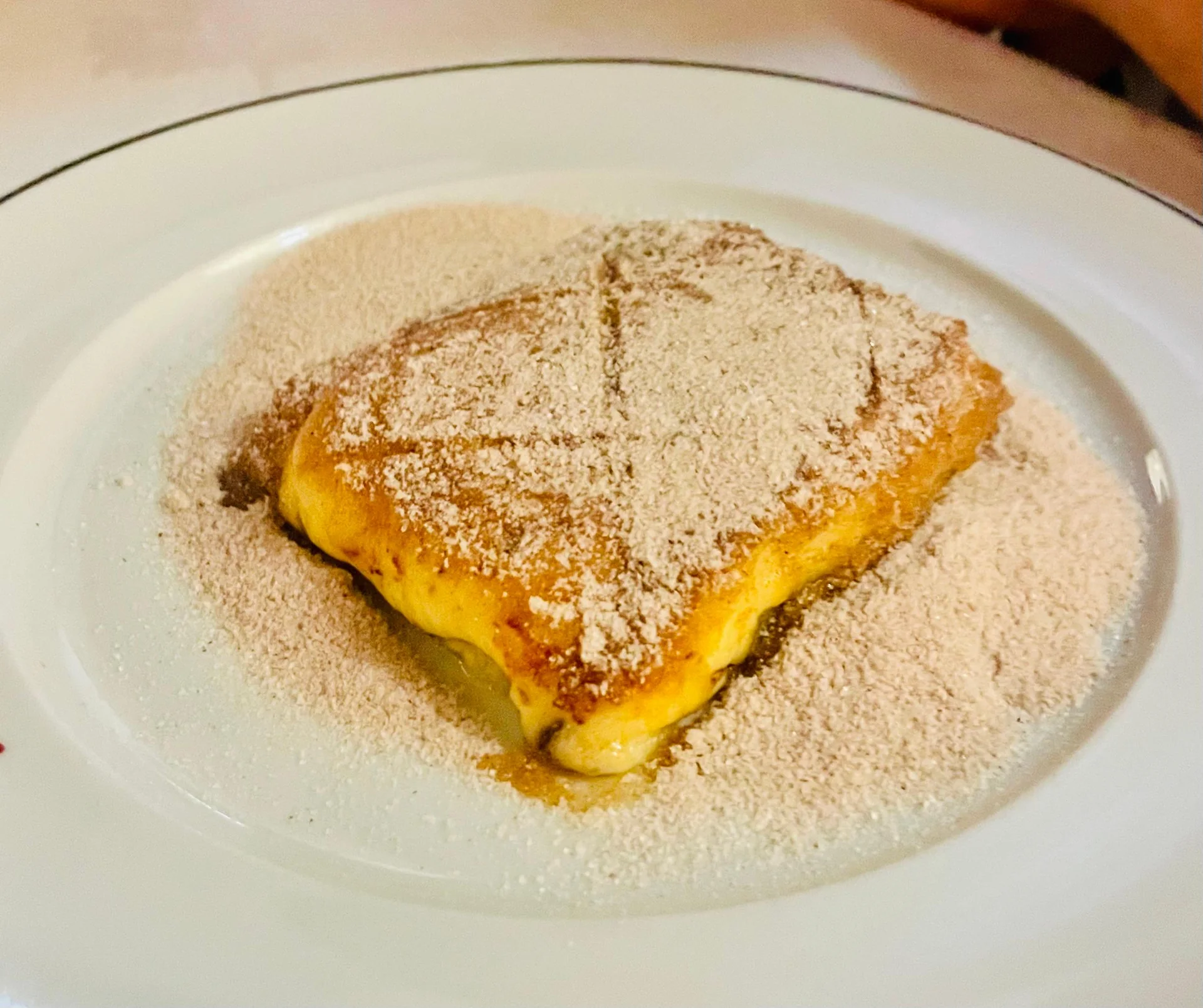 Porção de cartola servida em prato branco.