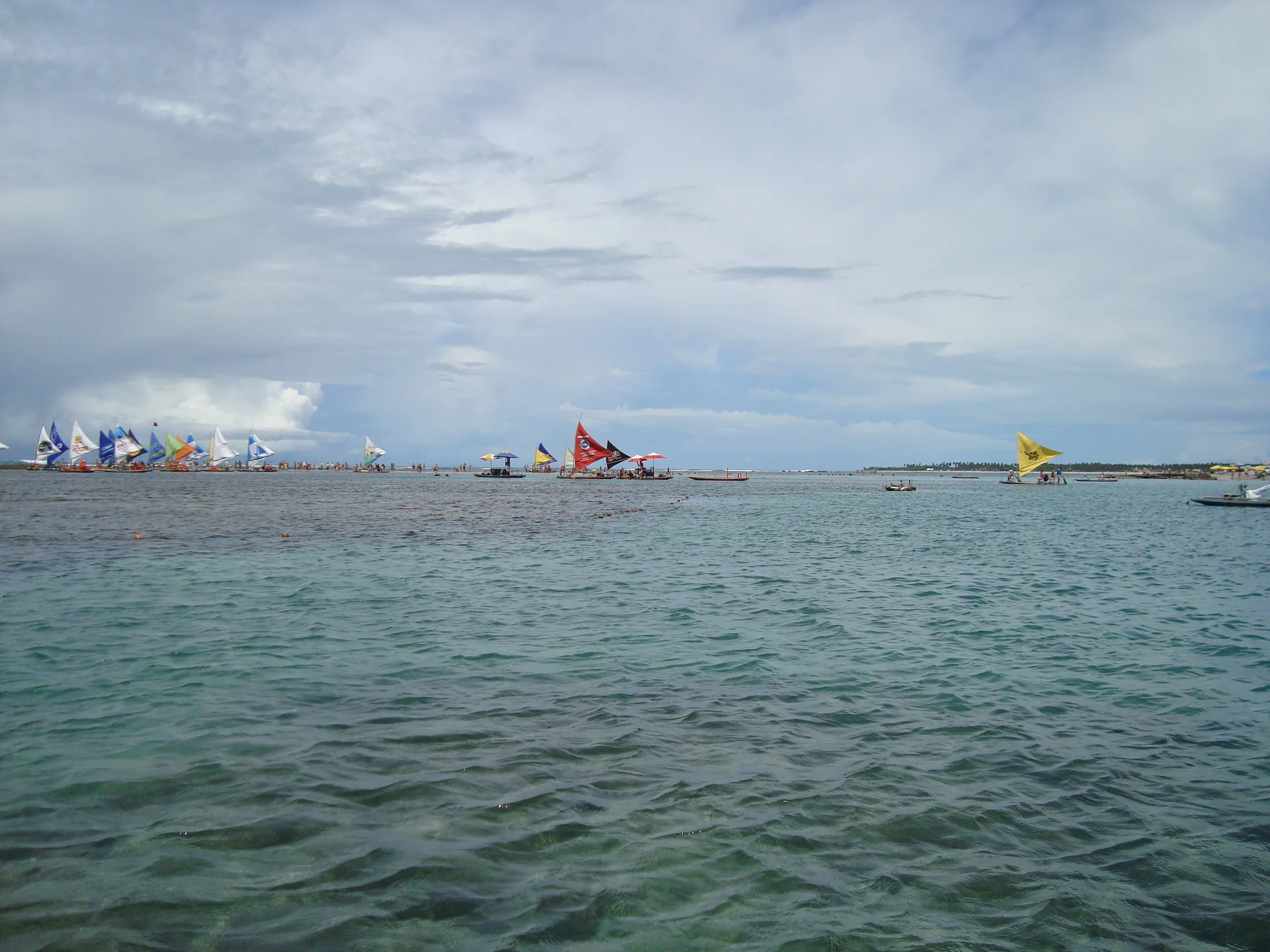 Mar de Porto de Galinhas com embarcações vistas à distância, em registro de 2009.