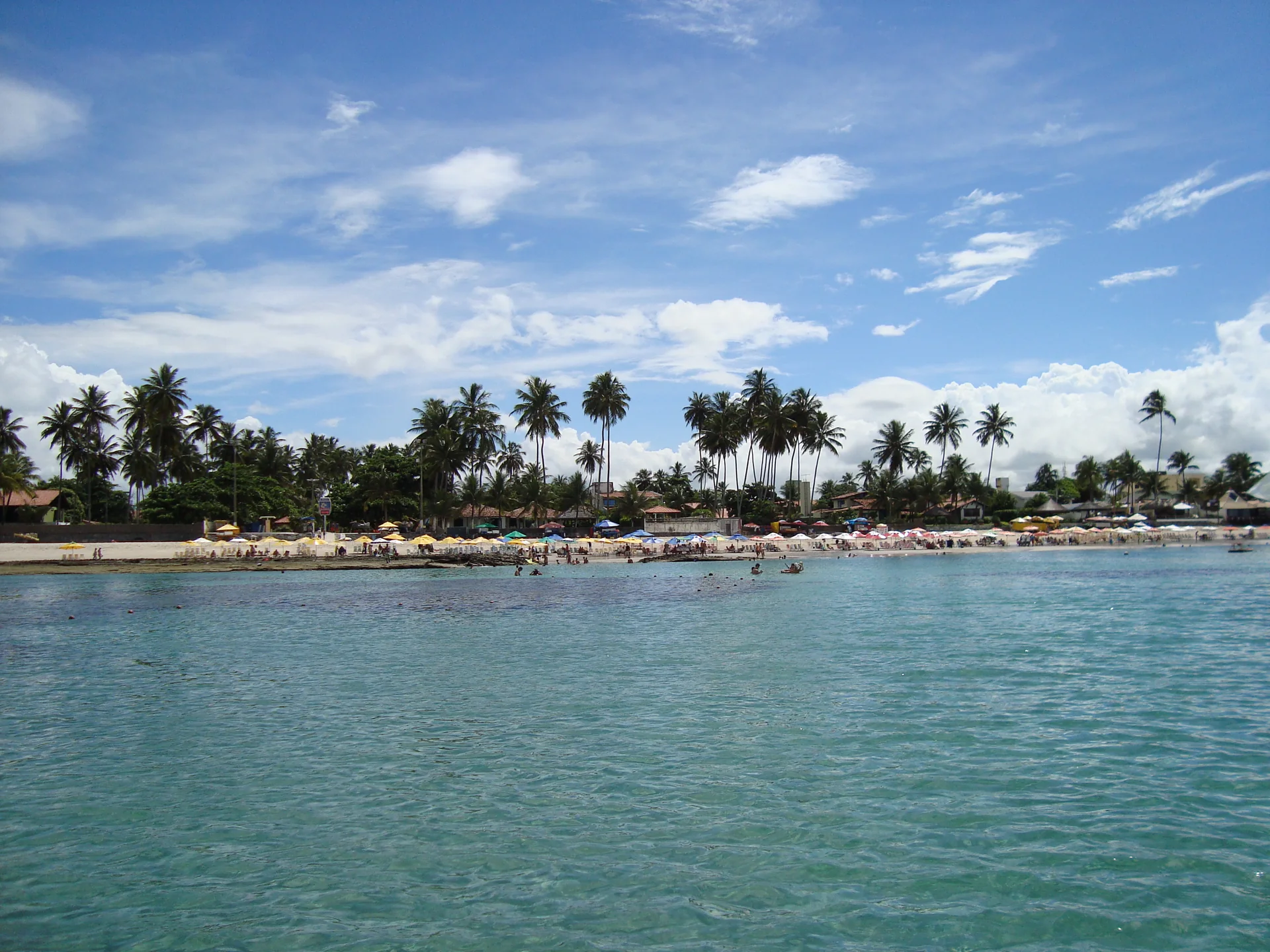 Vista distante da orla de Porto de Galinhas sob céu claro, em fotografia de 2009.