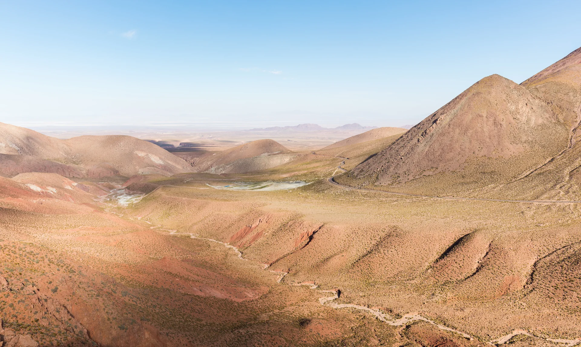 Paisagem árida do deserto de Atacama perto de Calama, com montanhas sob céu azul.