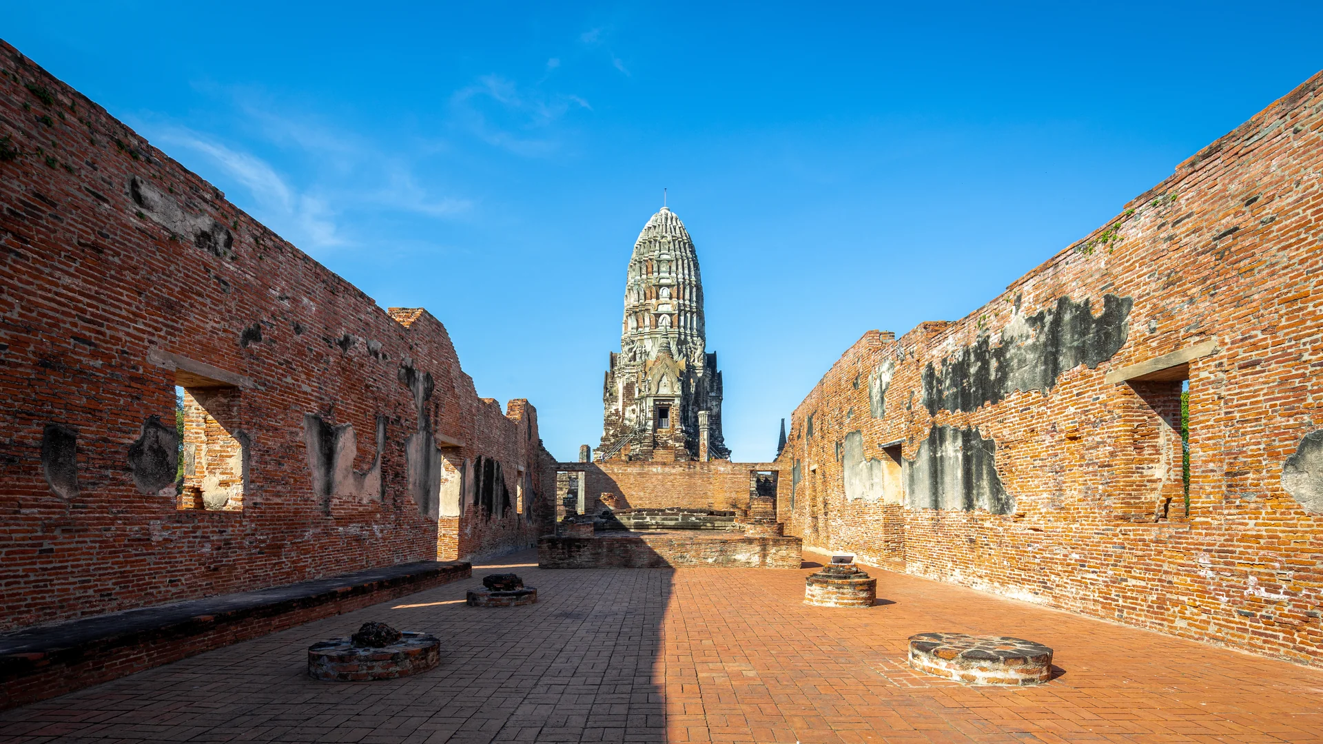 Prang principal de Wat Ratchaburana visto por um corredor de ruínas em Ayutthaya.