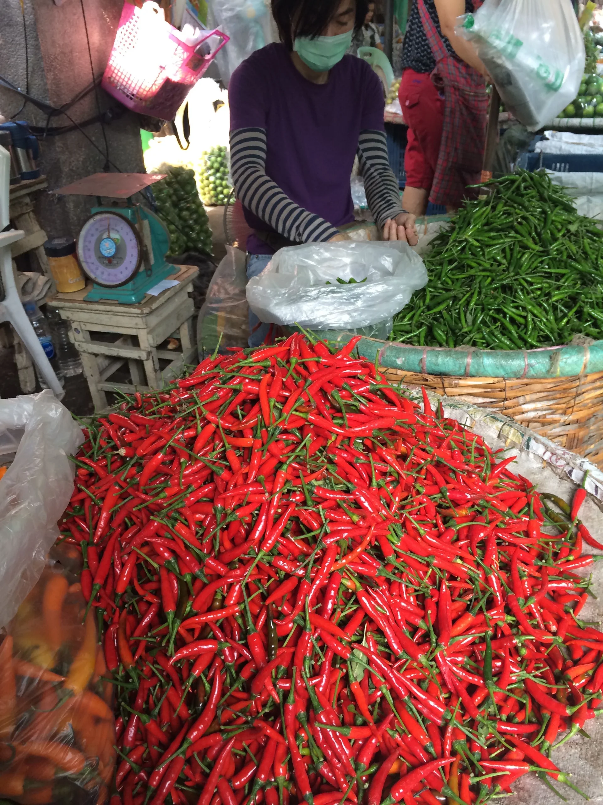 Pimentas vermelhas e verdes expostas em uma banca de rua em Bangkok.