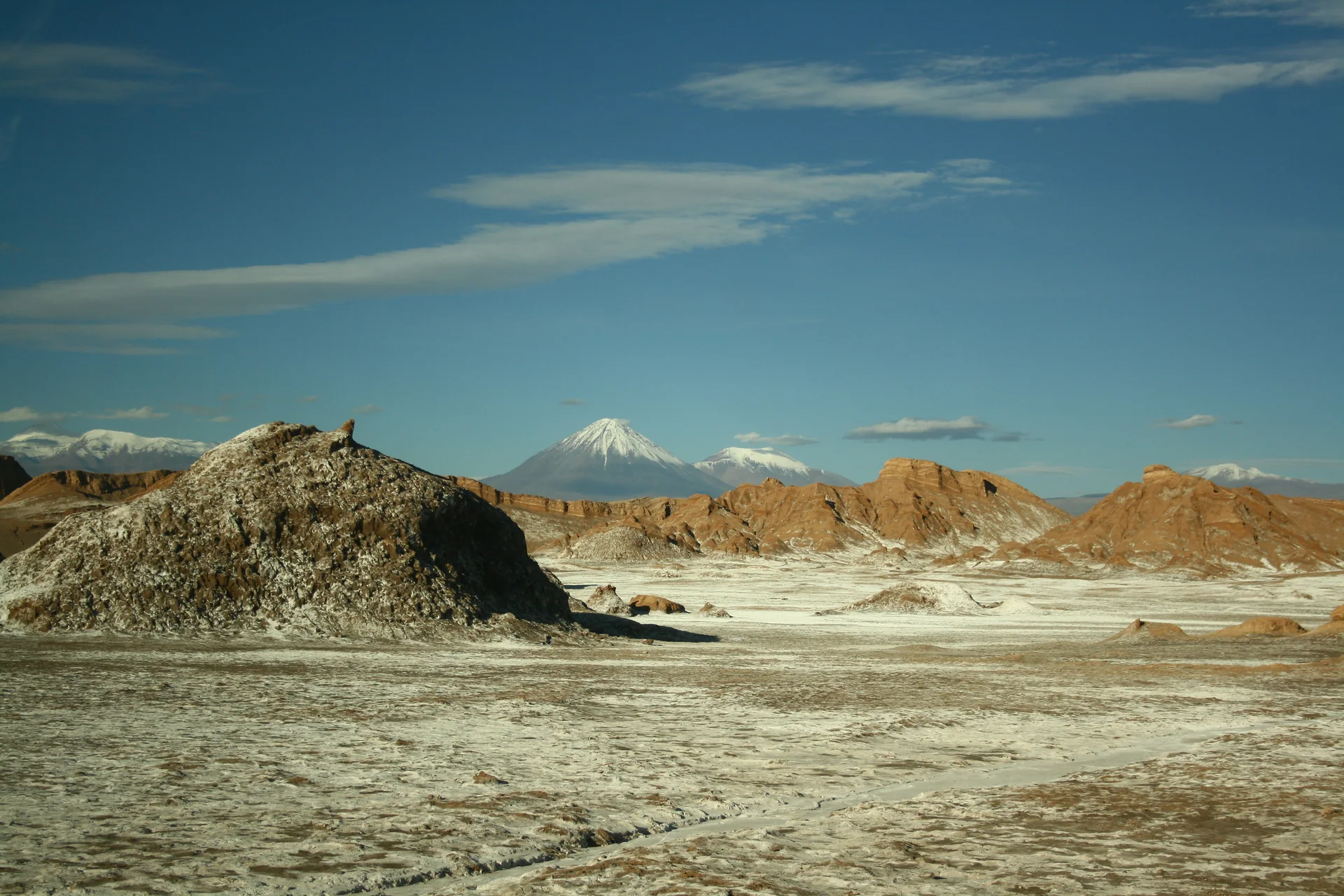 Panorama diurno de formações de pedra e sal na Cordillera de la Sal, no Valle de la Luna, sob céu azul claro.
