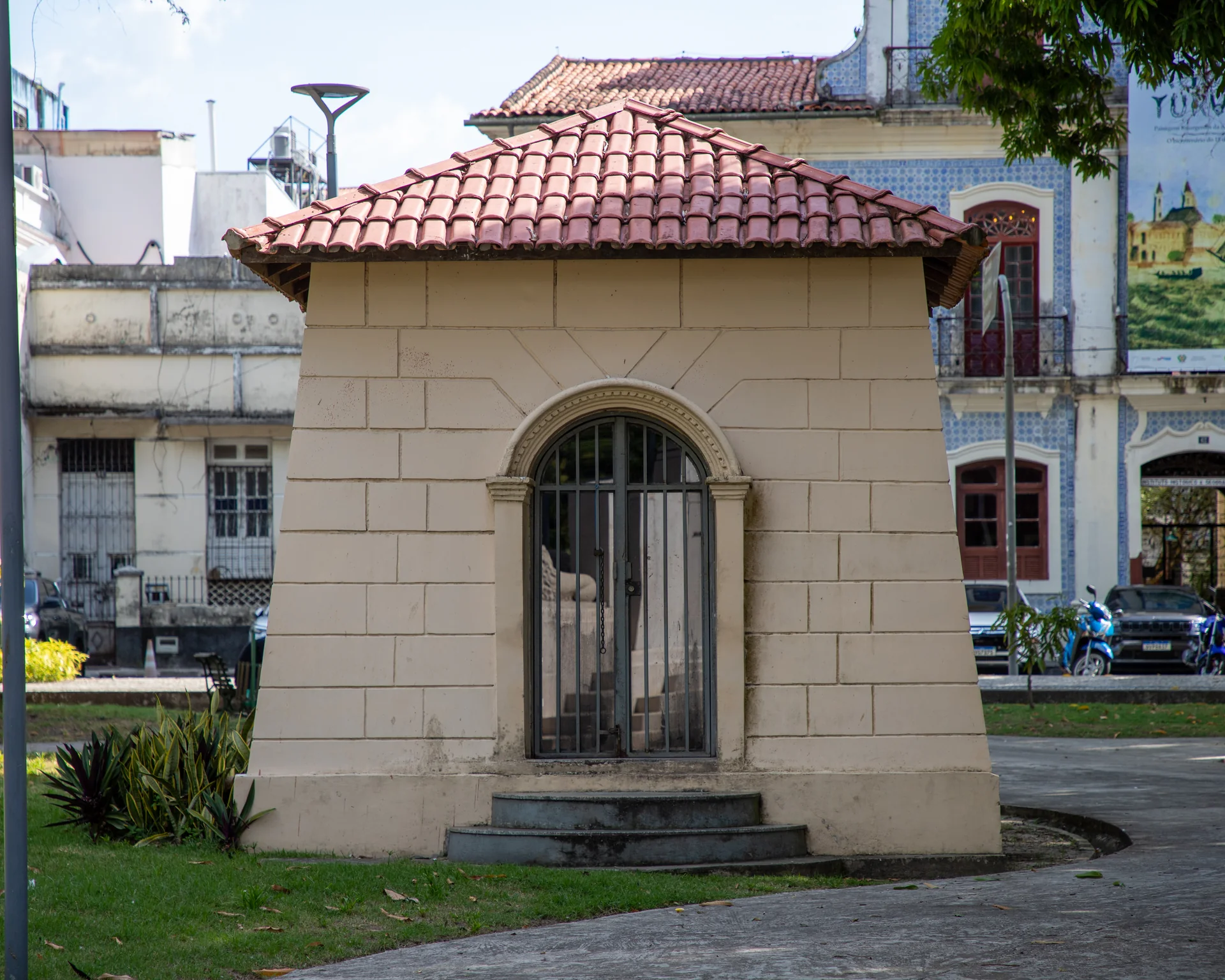Construção histórica com telhado de cerâmica e fachada de azulejos ao fundo, na Praça Dom Pedro II, na Cidade Velha de Belém.