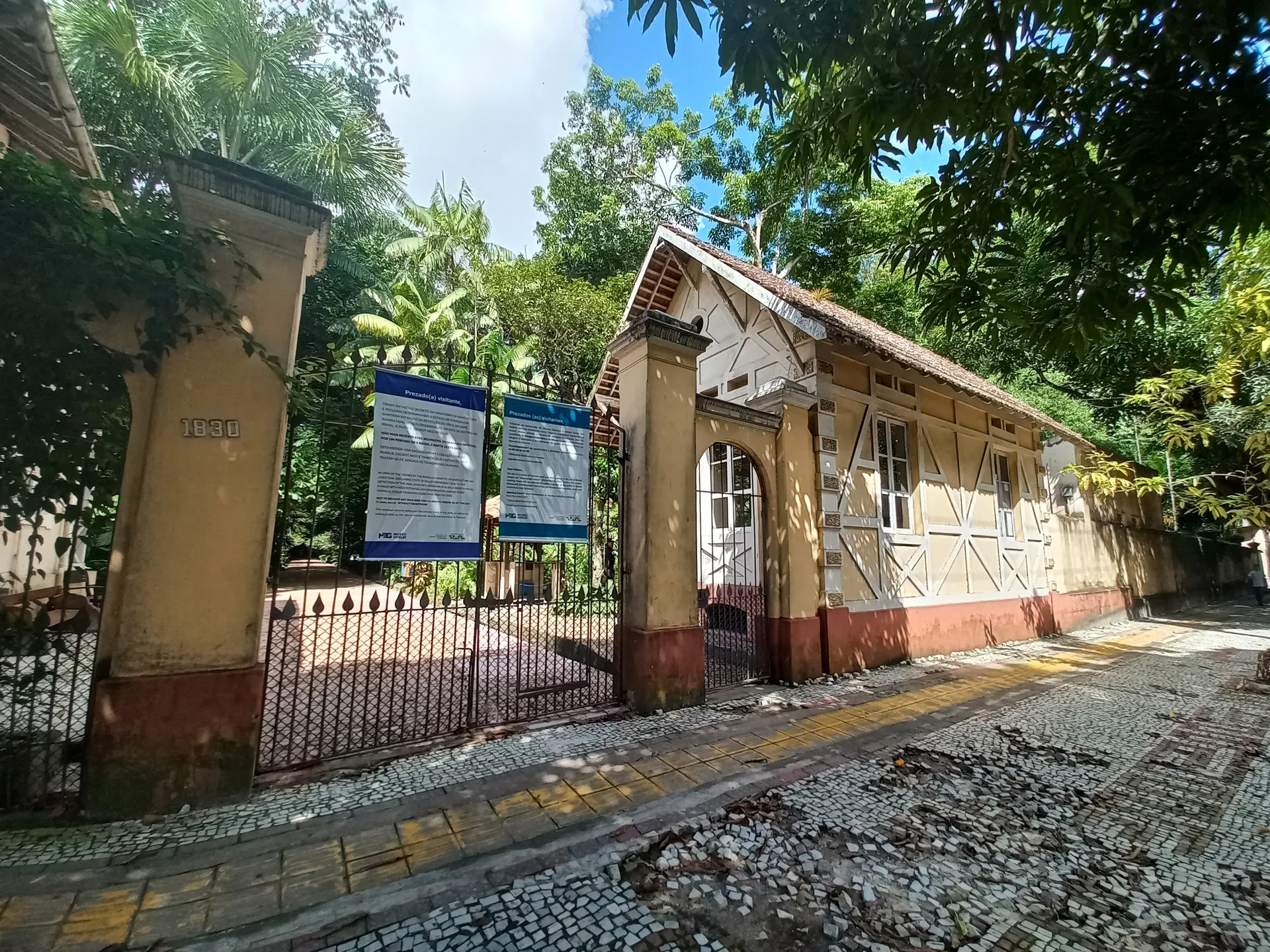 Entrada de uma edificação histórica cercada por vegetação no Parque Zoobotânico do Museu Paraense Emílio Goeldi, em Belém.