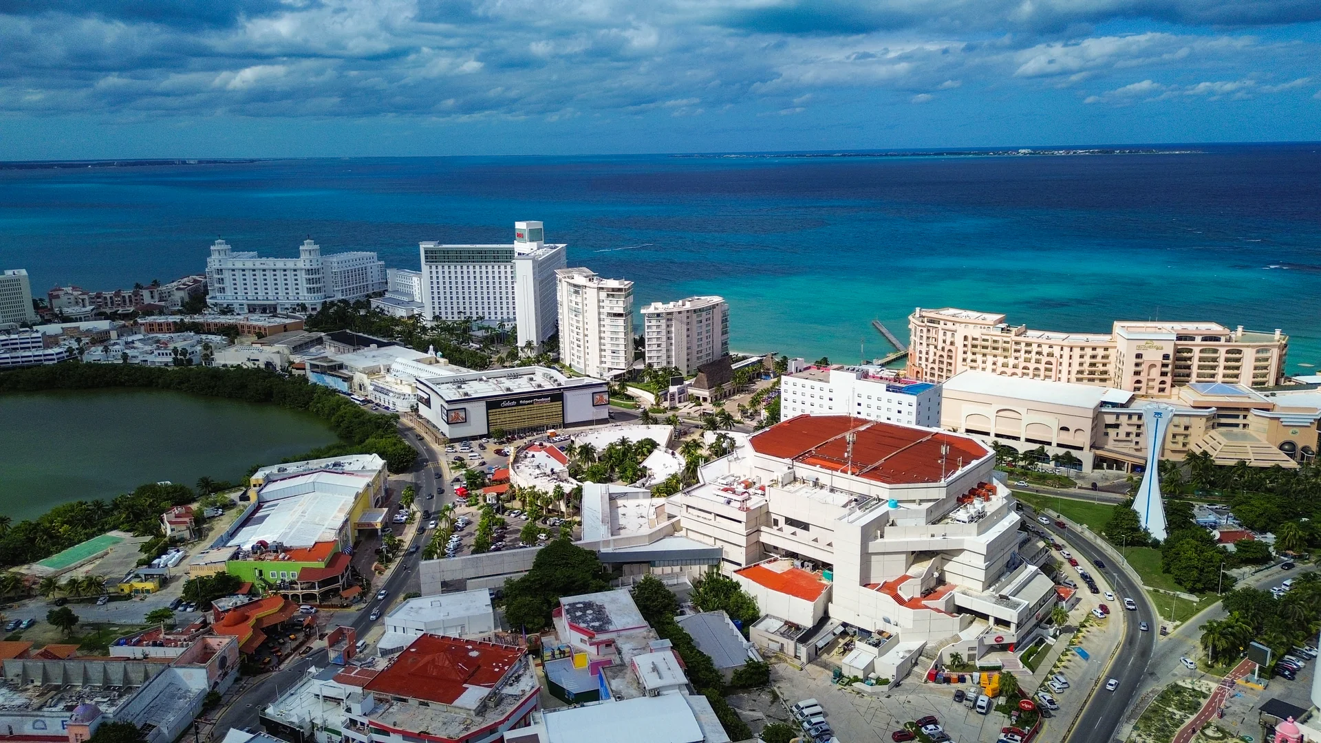 Vista aérea diurna da Zona Hoteleira de Punta Cancún, com edifícios junto à praia de Gaviota Azul e o Caribe azul ao fundo.