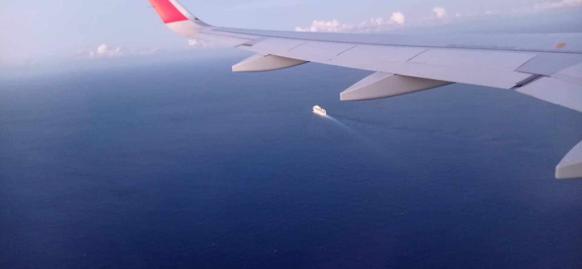Vista aérea diurna a partir de uma aeronave, com a asa sobre o mar azul próximo de Cancún.