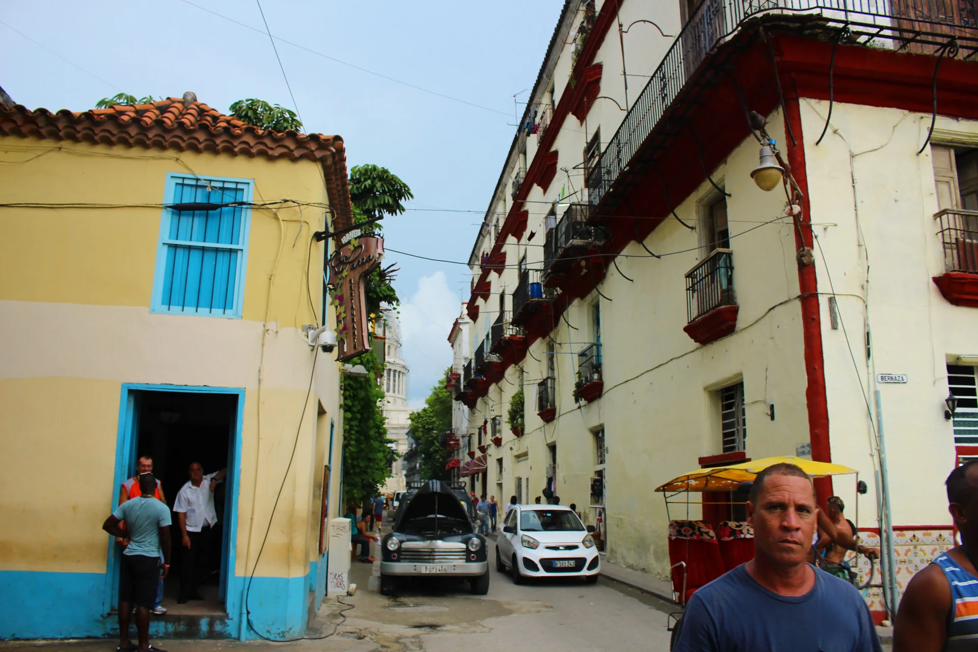 Rua Brasil, também conhecida como Teniente Rey, em Habana Vieja, com fachadas coloridas, veículos estacionados e luz natural no fim do dia.