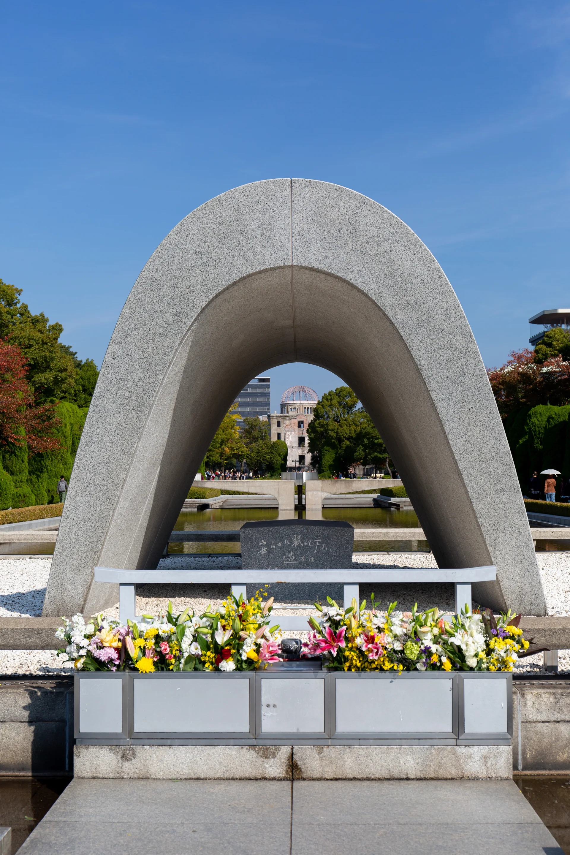 Cenotáfio Memorial no Parque Memorial da Paz de Hiroshima, com o Domo de Genbaku ao fundo.