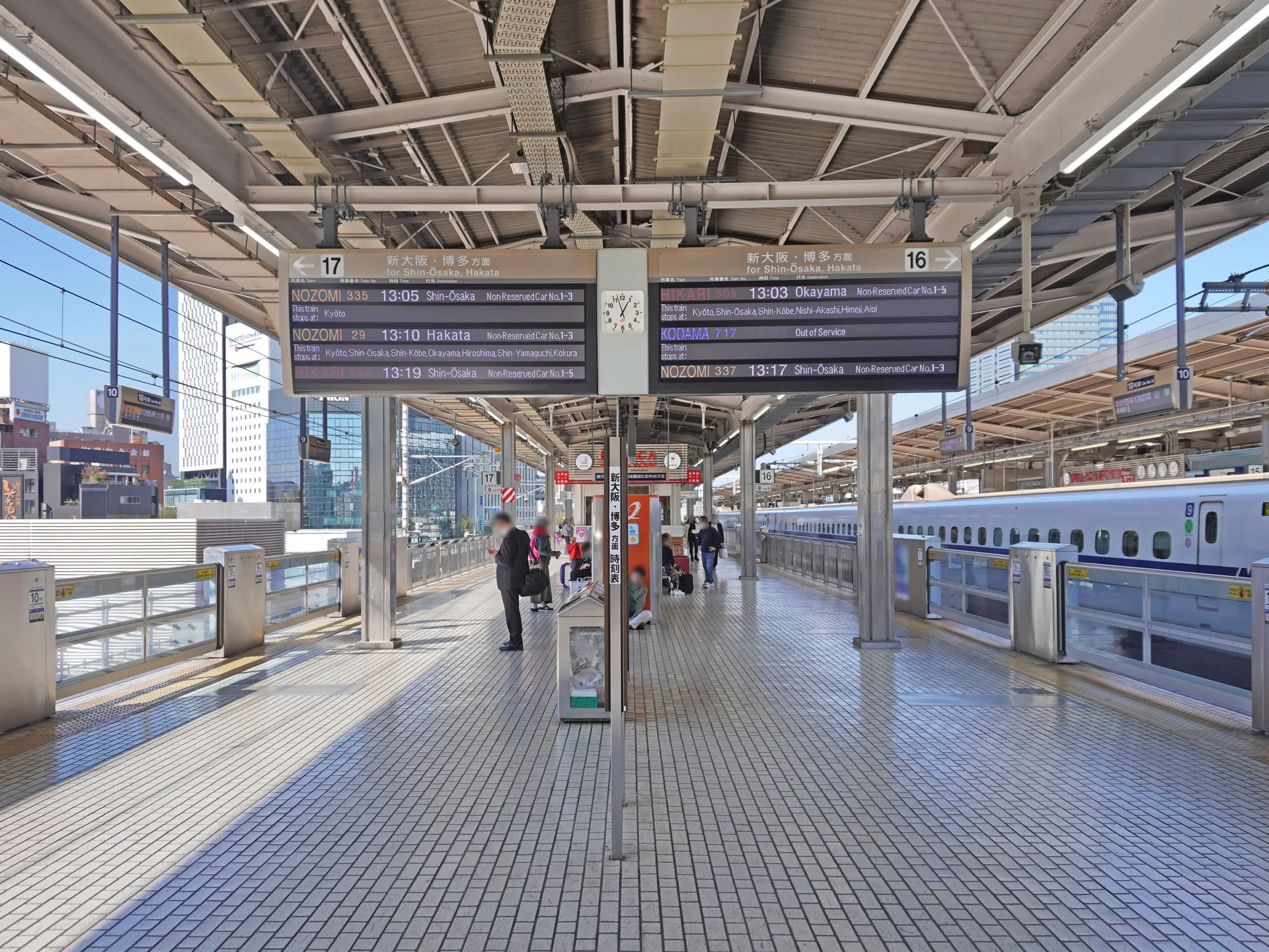 Plataformas 16 e 17 do shinkansen na Estação de Nagoya, com painéis de partida e trem ao lado.