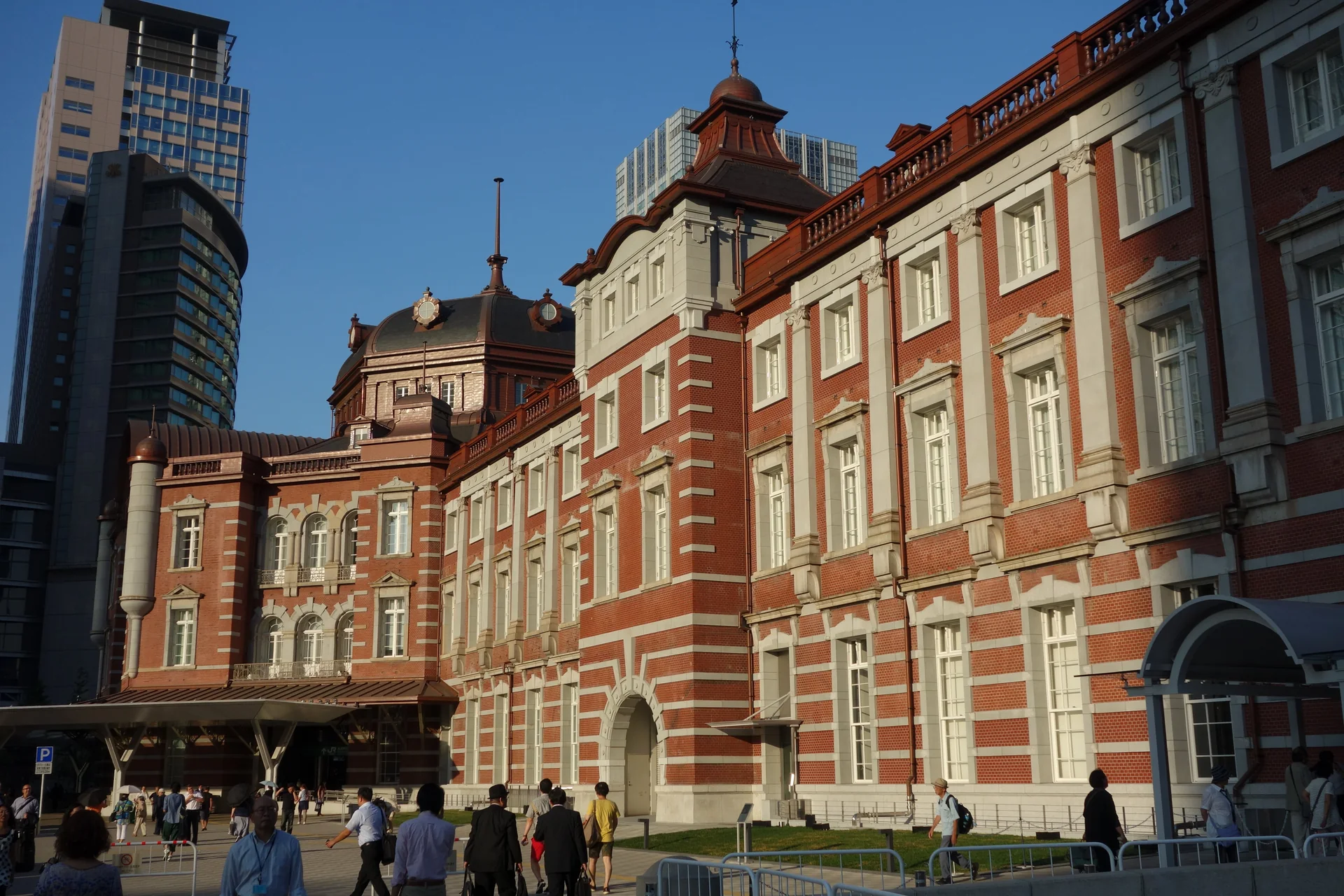 Fachada histórica de tijolos vermelhos do edifício Marunouchi da Estação Tokyo em fim de tarde claro.