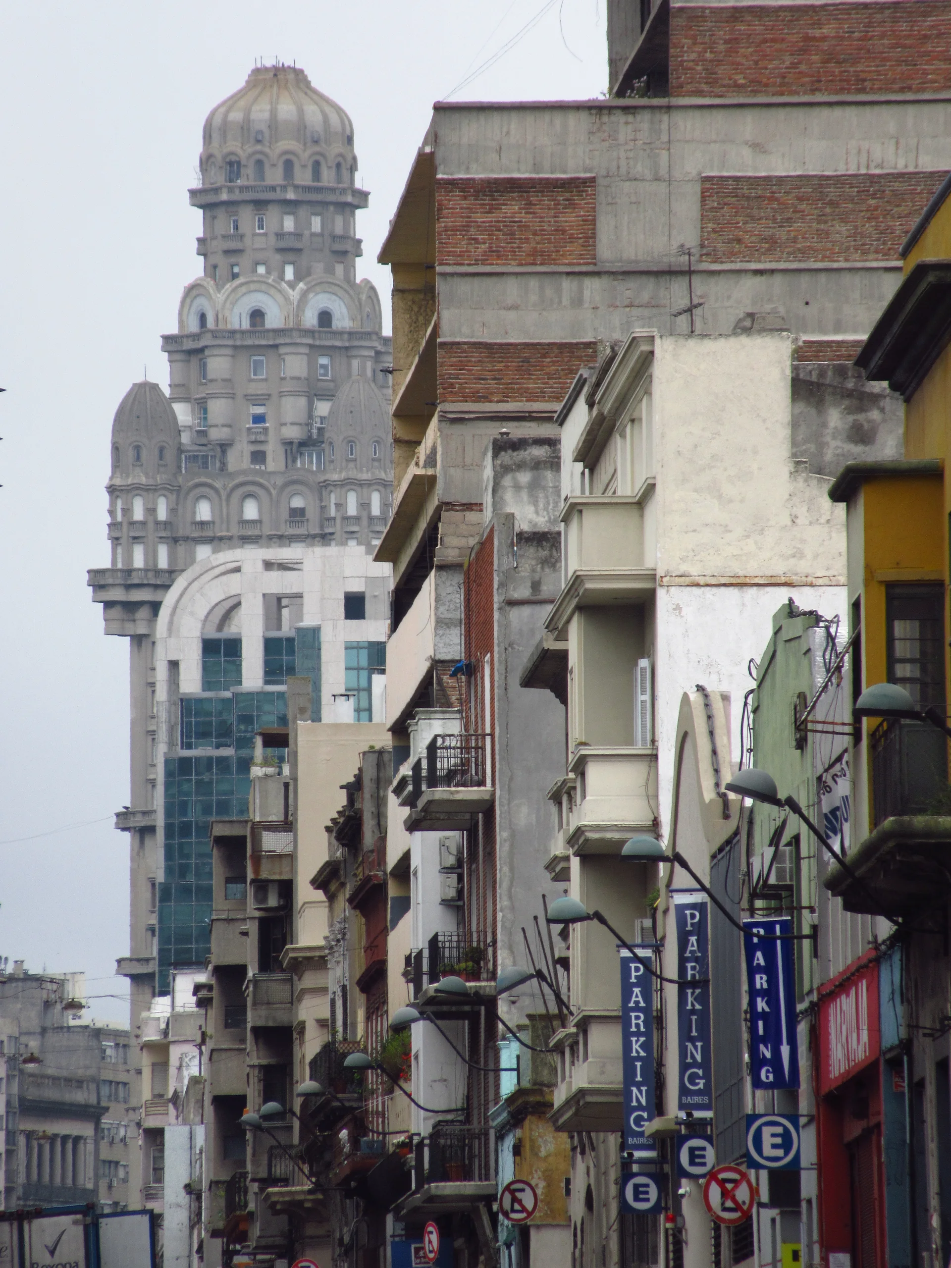 Rua da Ciudad Vieja de Montevidéu com fachadas históricas e a torre do Palacio Salvo ao fundo.