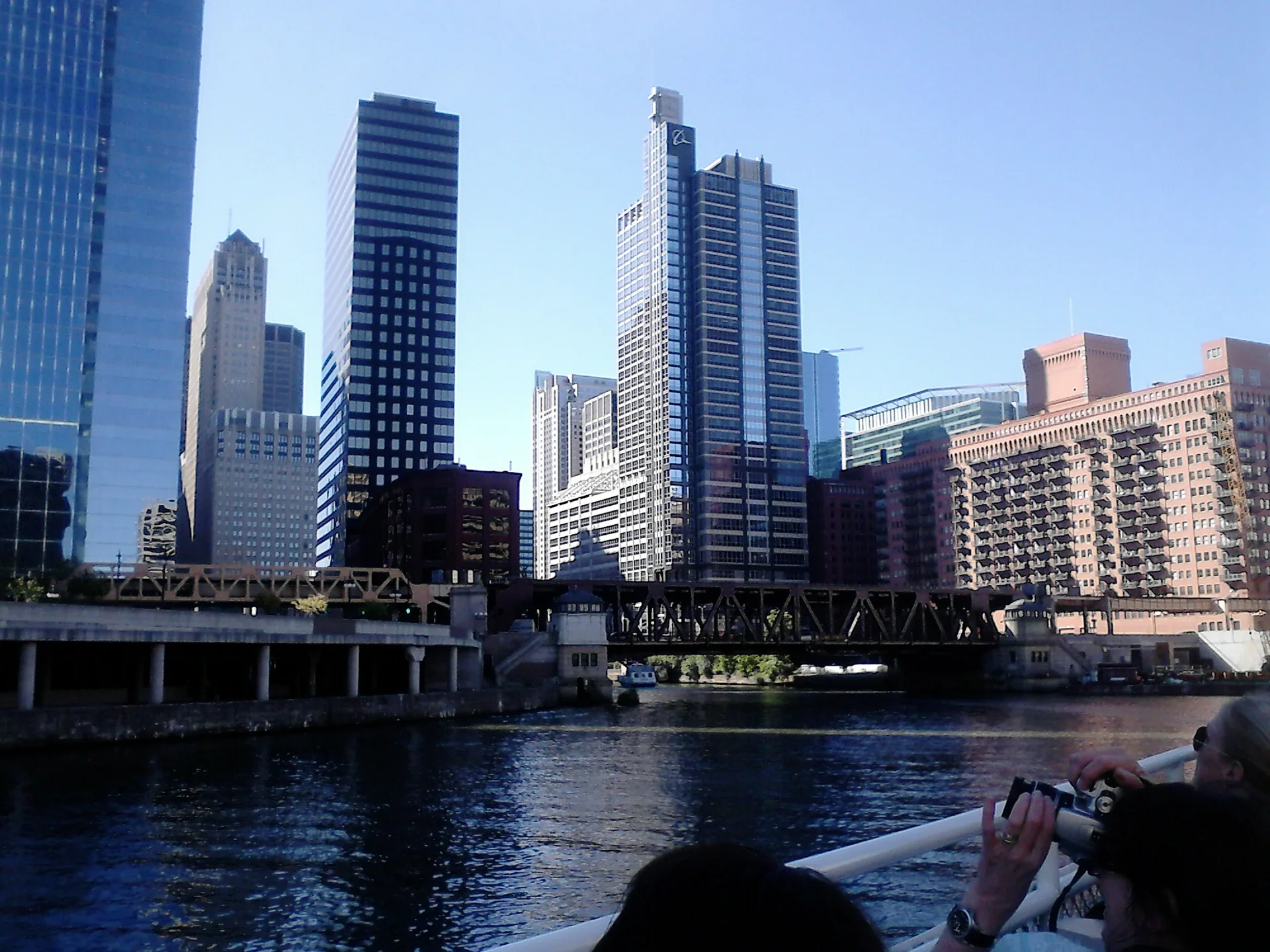 Vista diurna do Chicago River no Loop, com pontes e skyline sob céu claro.