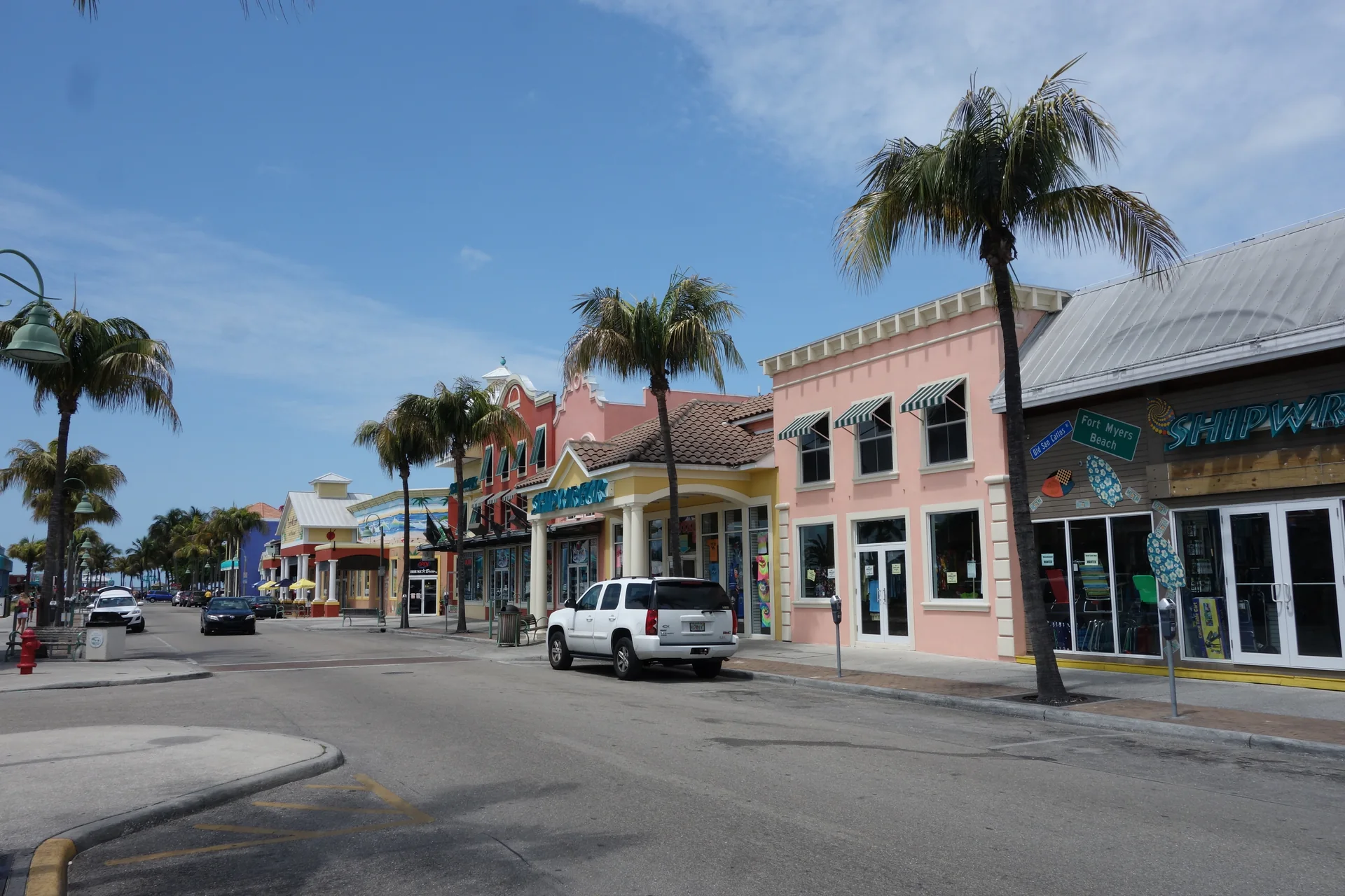 Rua do centro histórico de Fort Myers com edifícios baixos, palmeiras e céu claro.