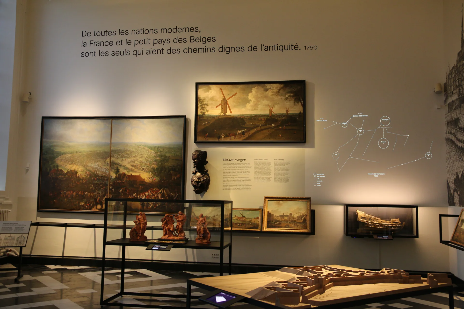 Sala de exposição do STAM com pinturas, maquete urbana e recursos interpretativos sobre a história de Gante.