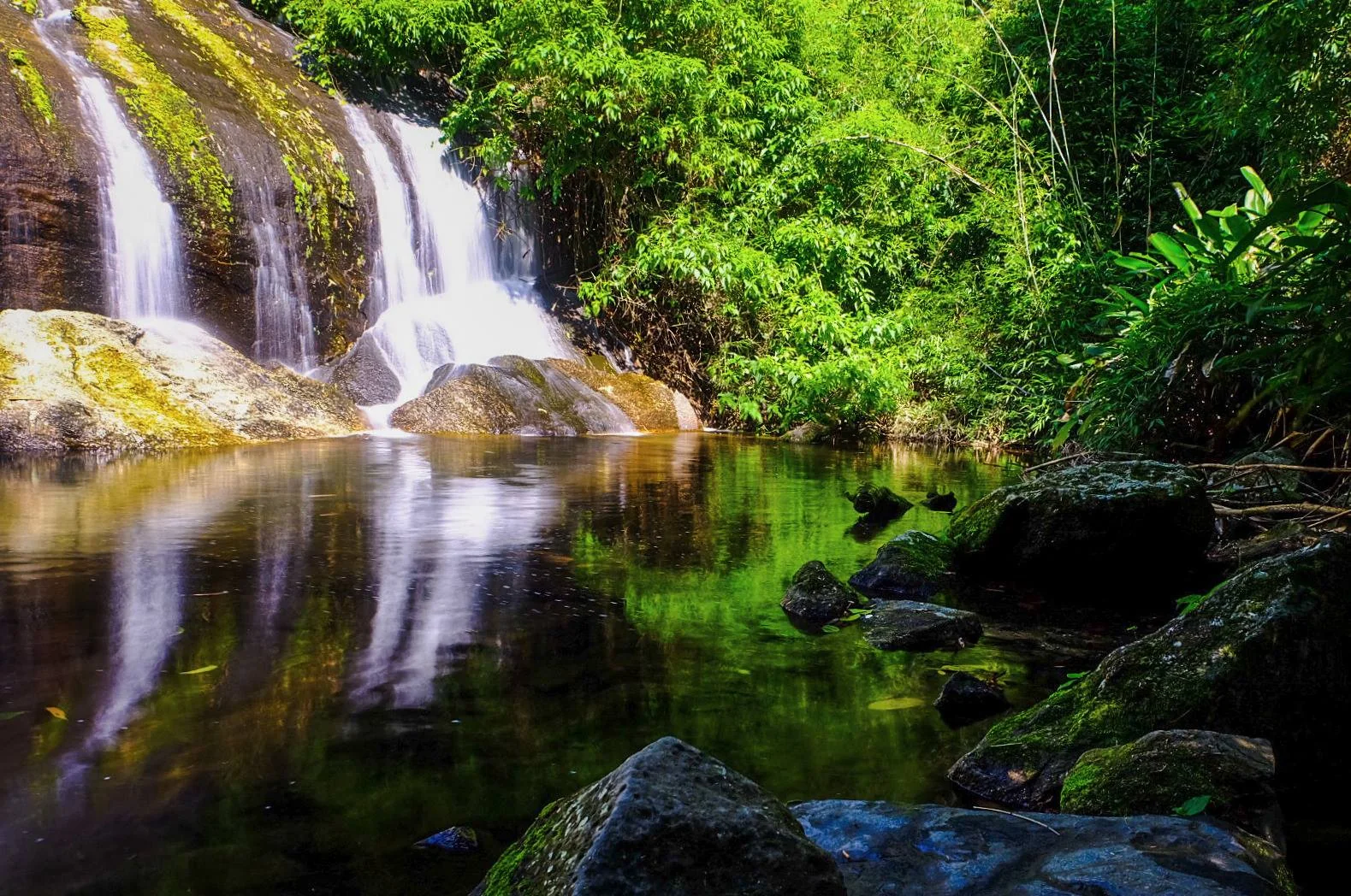 Poço e queda d’água entre rochas e Mata Atlântica no início da Trilha da Cachoeira da Pancada d’Água, em Ilhabela.